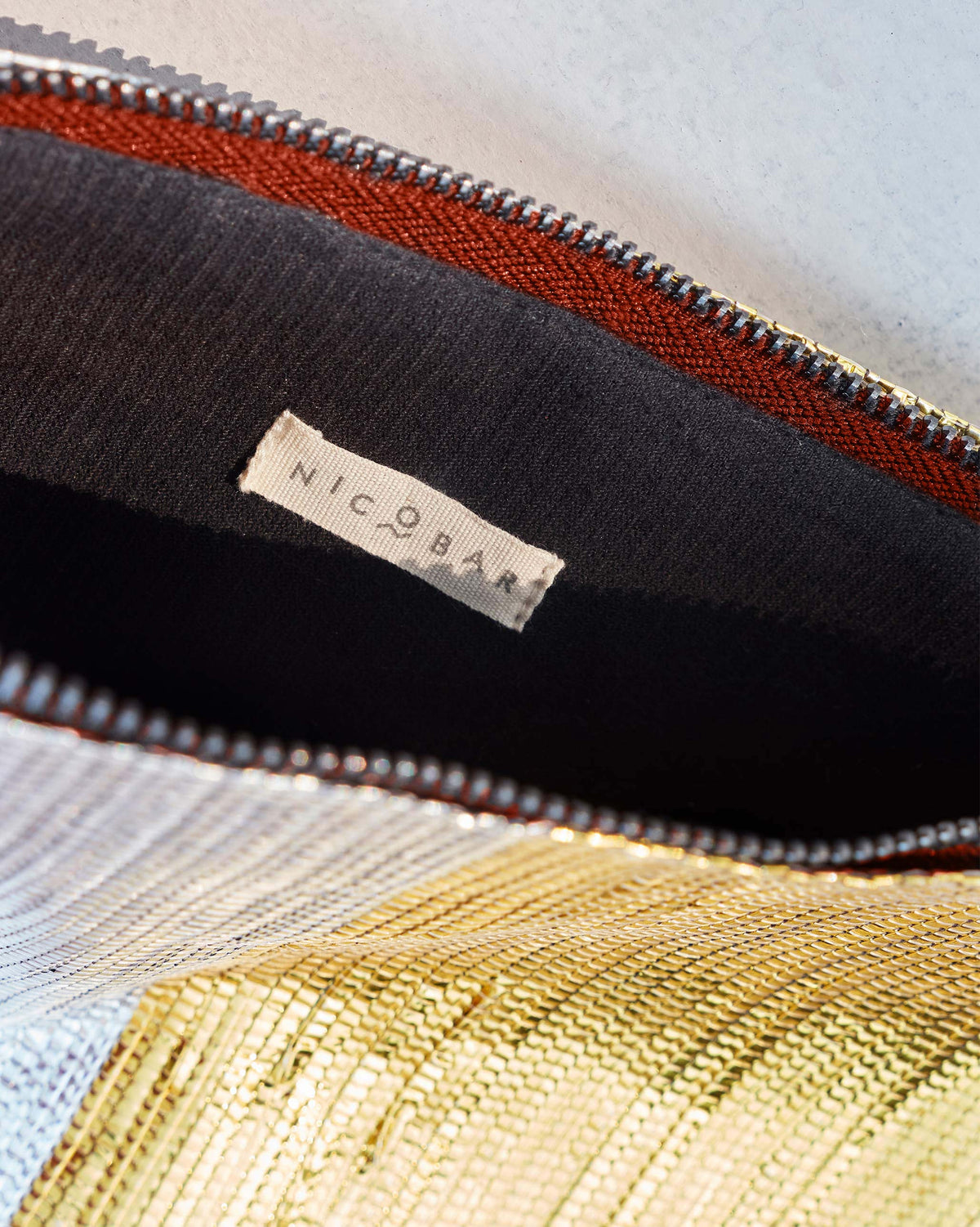 Inside of the Sitara Clutch showing its black lining and zip.
