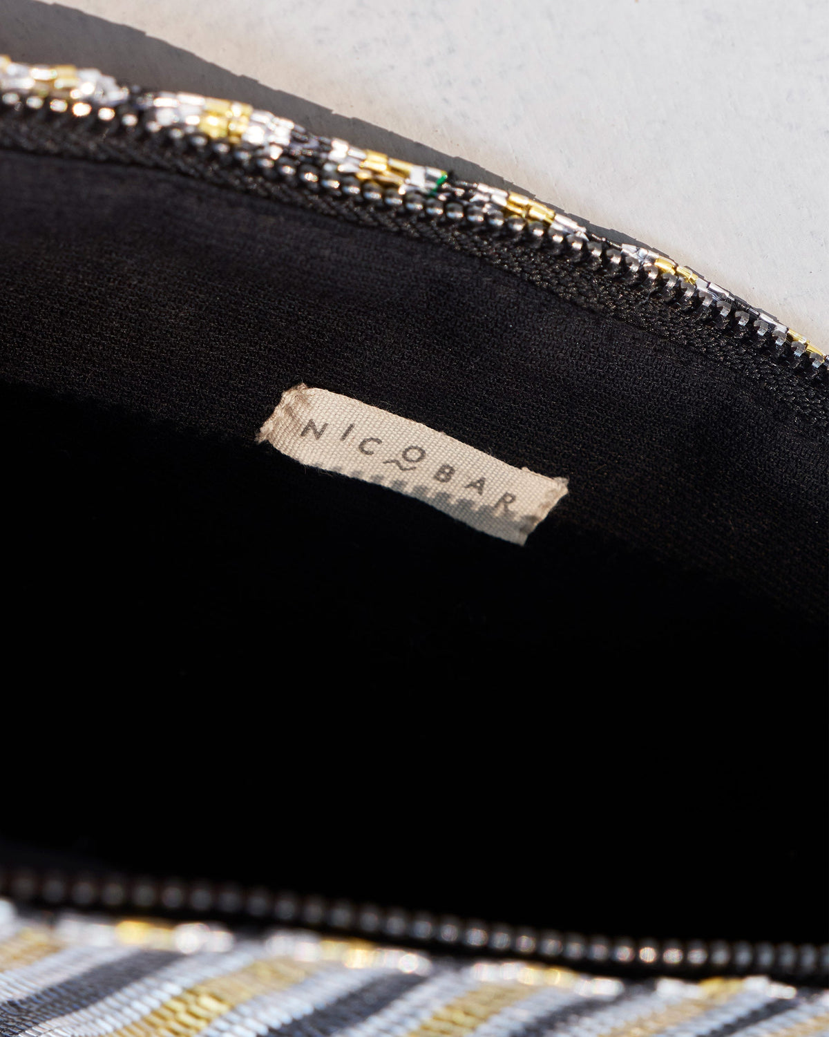 Inside of the Sitara Clutch showing its black lining and zip.