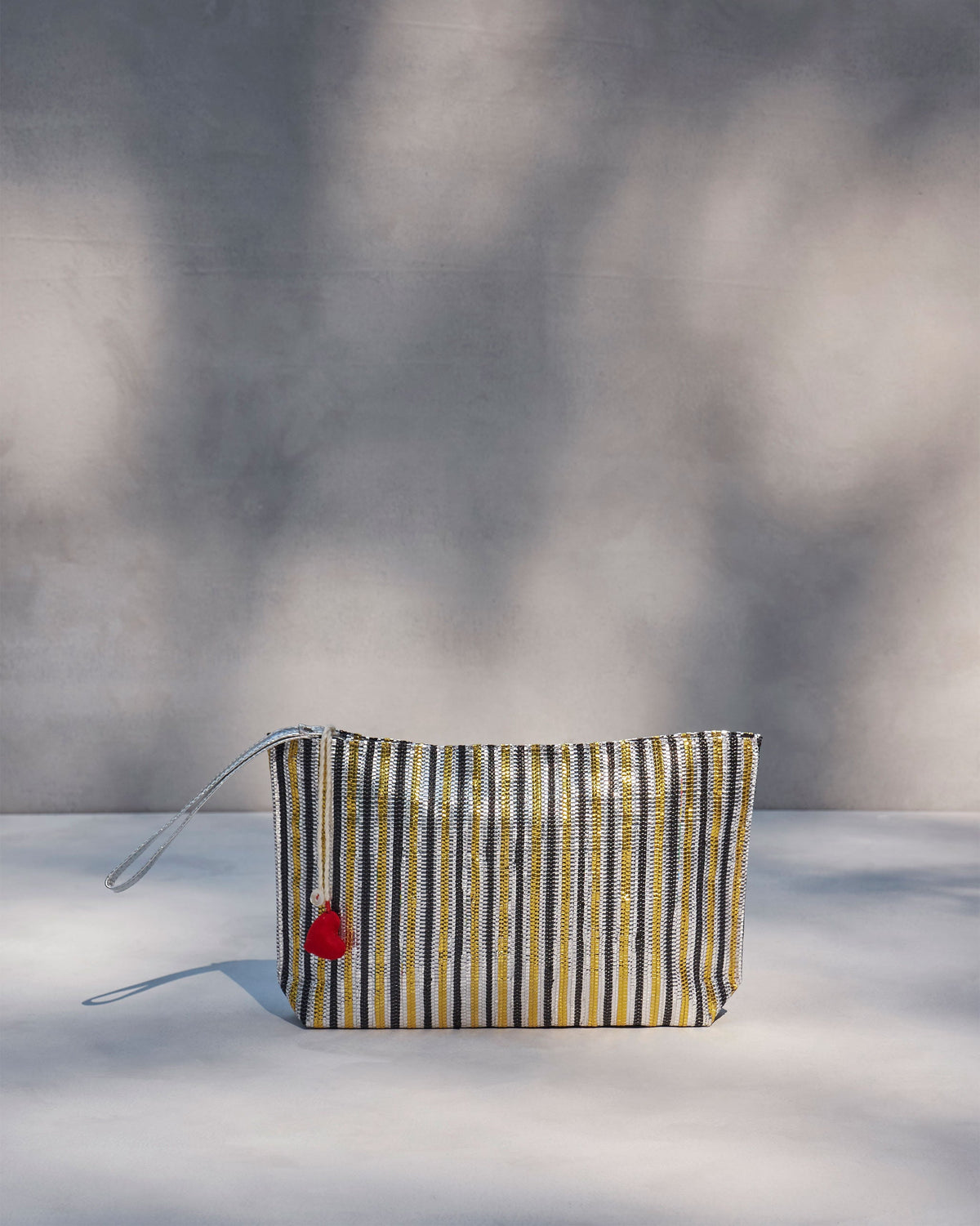 Sitara Clutch standing upright, showing its gold and black stripes.