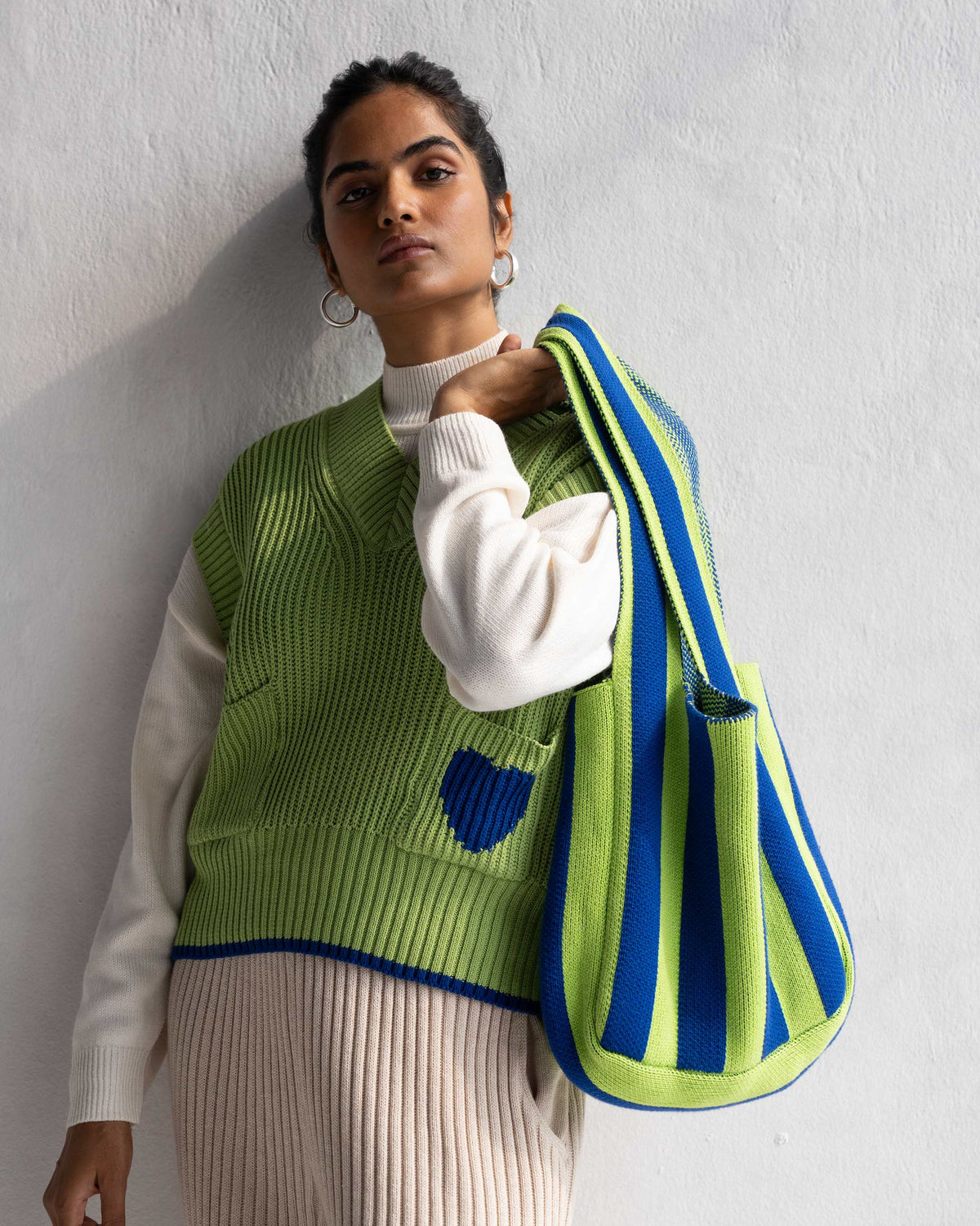 Person holding the Stripe Bag on one shoulder, showing its blue and green stripes.