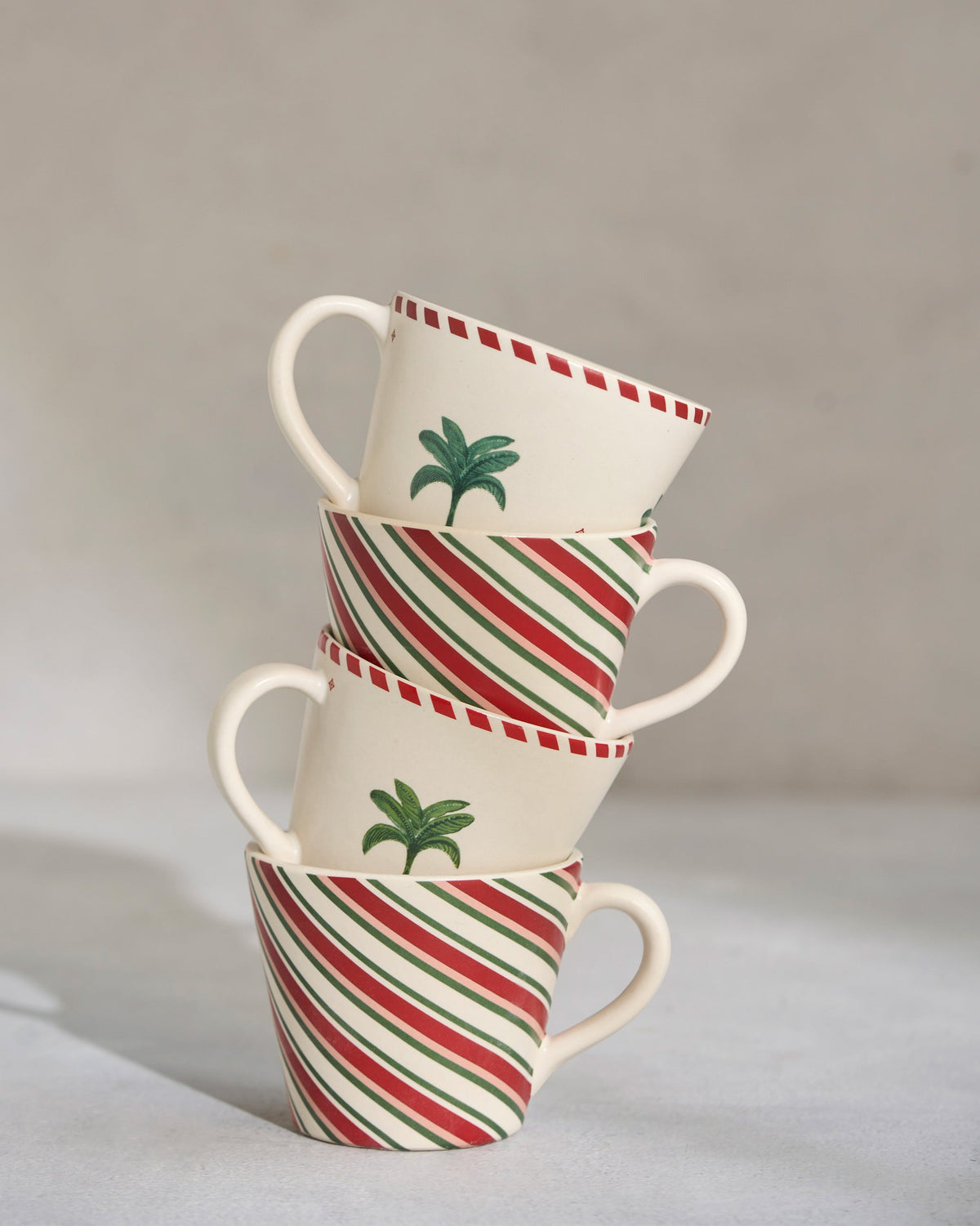 Four Whimsical Espresso Mugs stacked, with palm motifs alternating with red and green stripes.