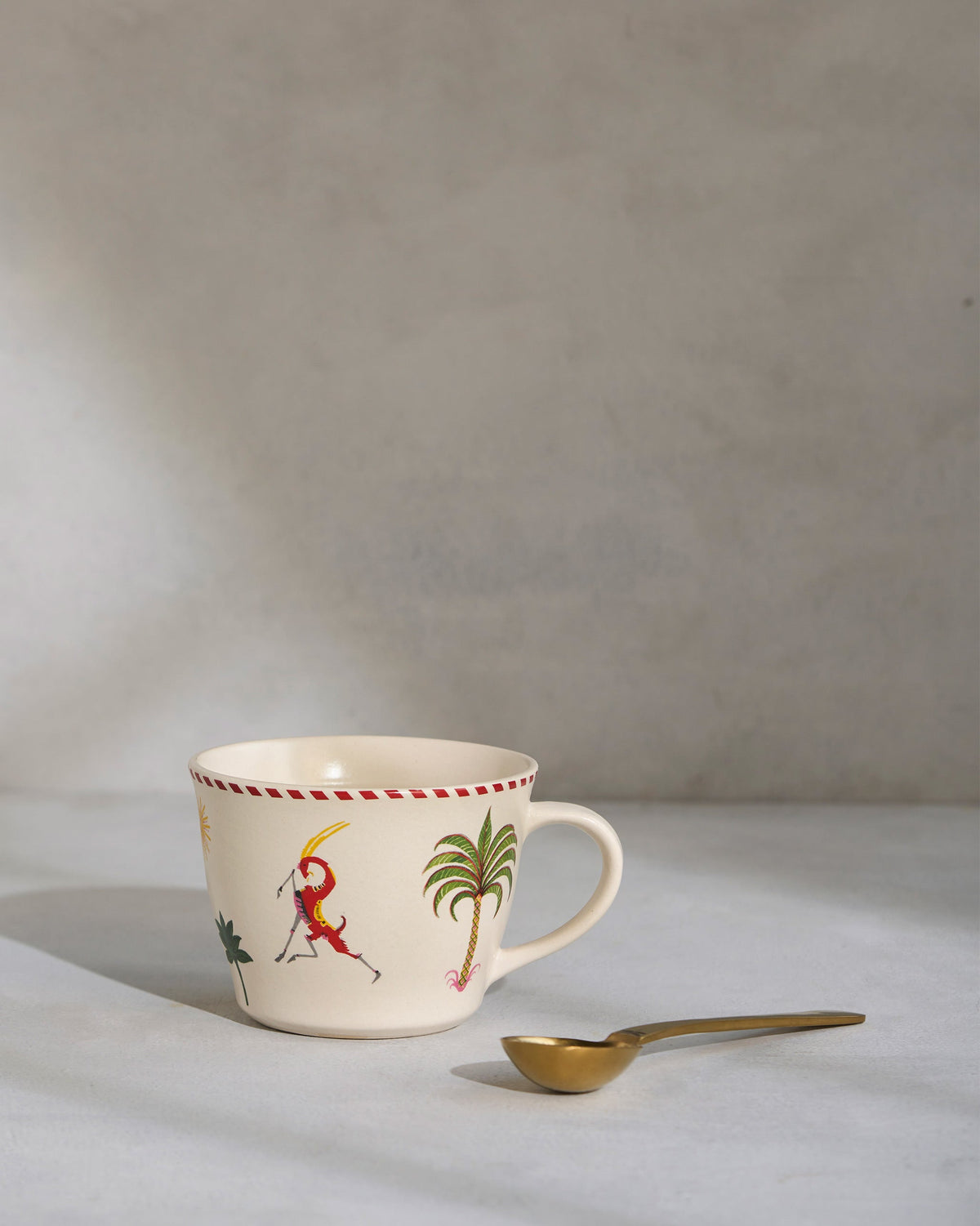 Mare Soup Mug with a red figure and a palm tree on its side, seen at an angle.