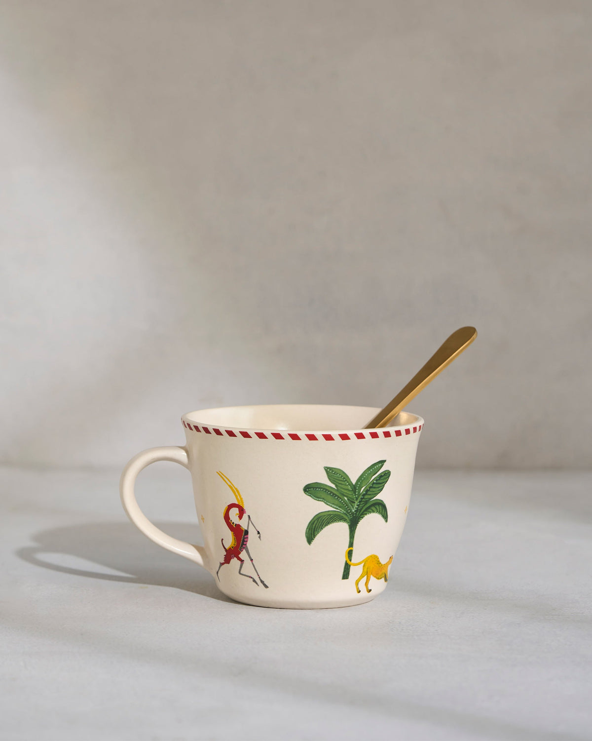 Close-up of a Mare Soup Mug showing a palm tree design and red-dotted rim.