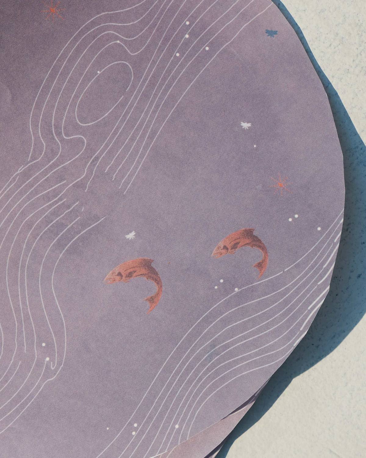 Close-up of Contour parchment paper showing rust fish motifs and white contour lines.