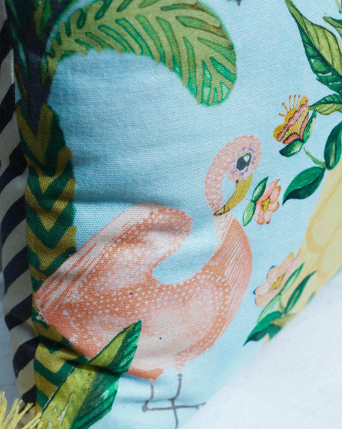 Close-up of the Zanzibar cushion cover showing a pink flamingo and leaves.