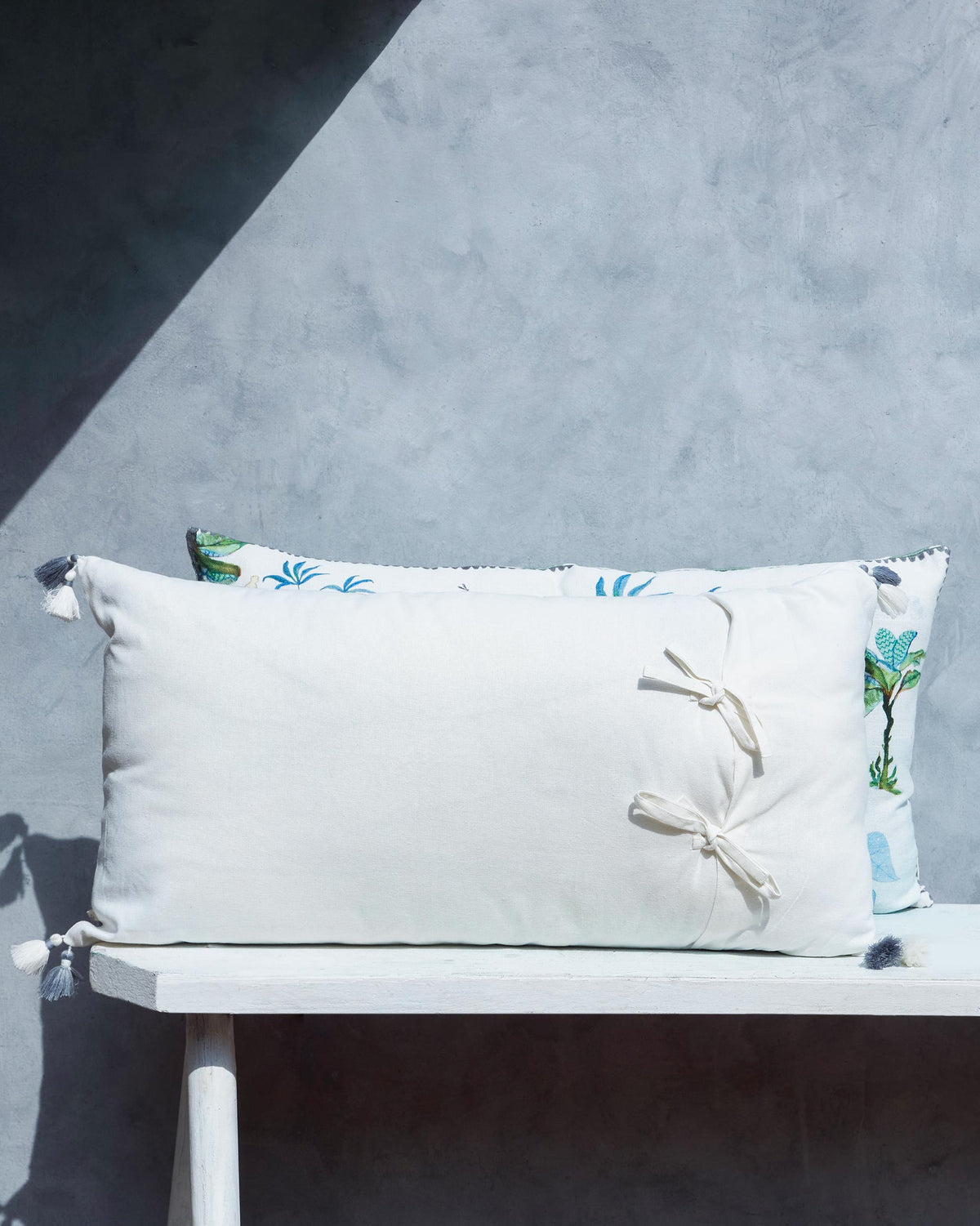 Back of Joyful Cushion Cover in cream with two bow ties.