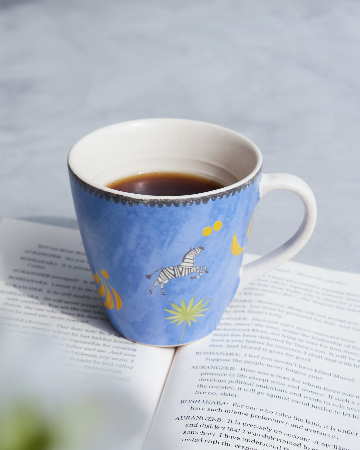 Blue Zebra Conical Mug with a leaping zebra, bananas and a palm motif.