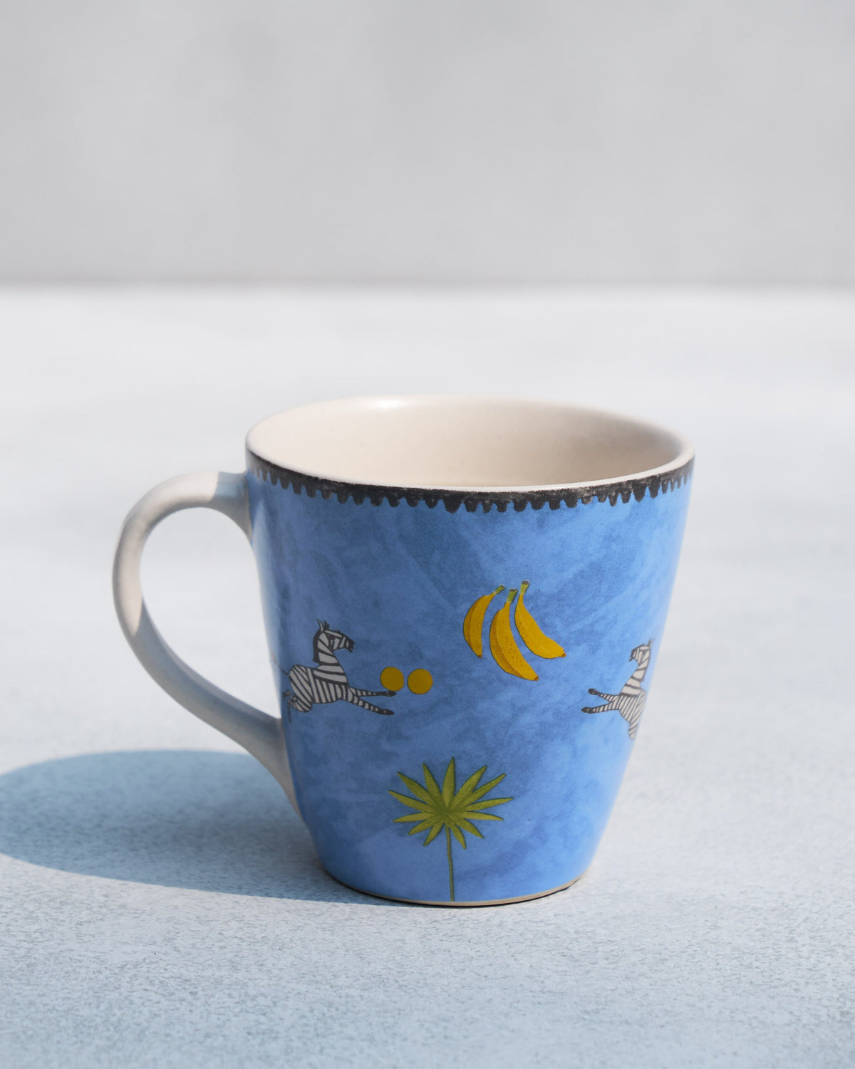 Blue Zebra Conical Mug turned to show its handle on the left.