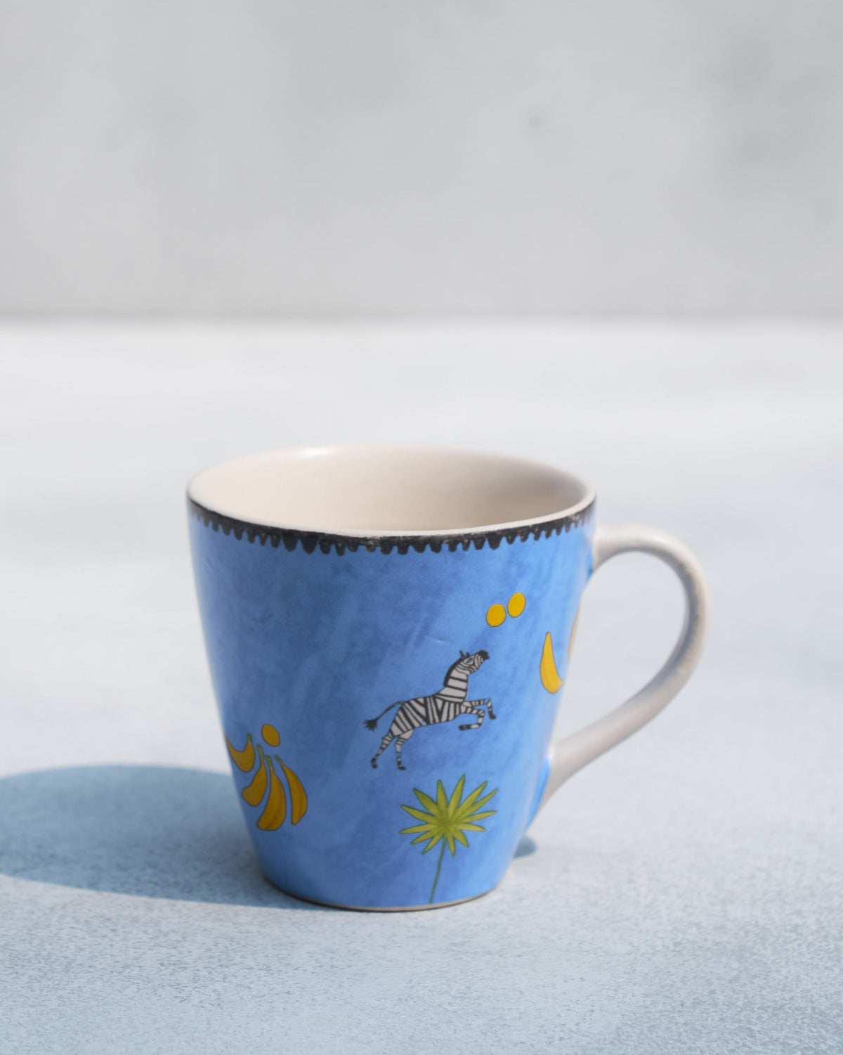Blue Zebra Conical Mug with its handle on the right and a zebra motif.
