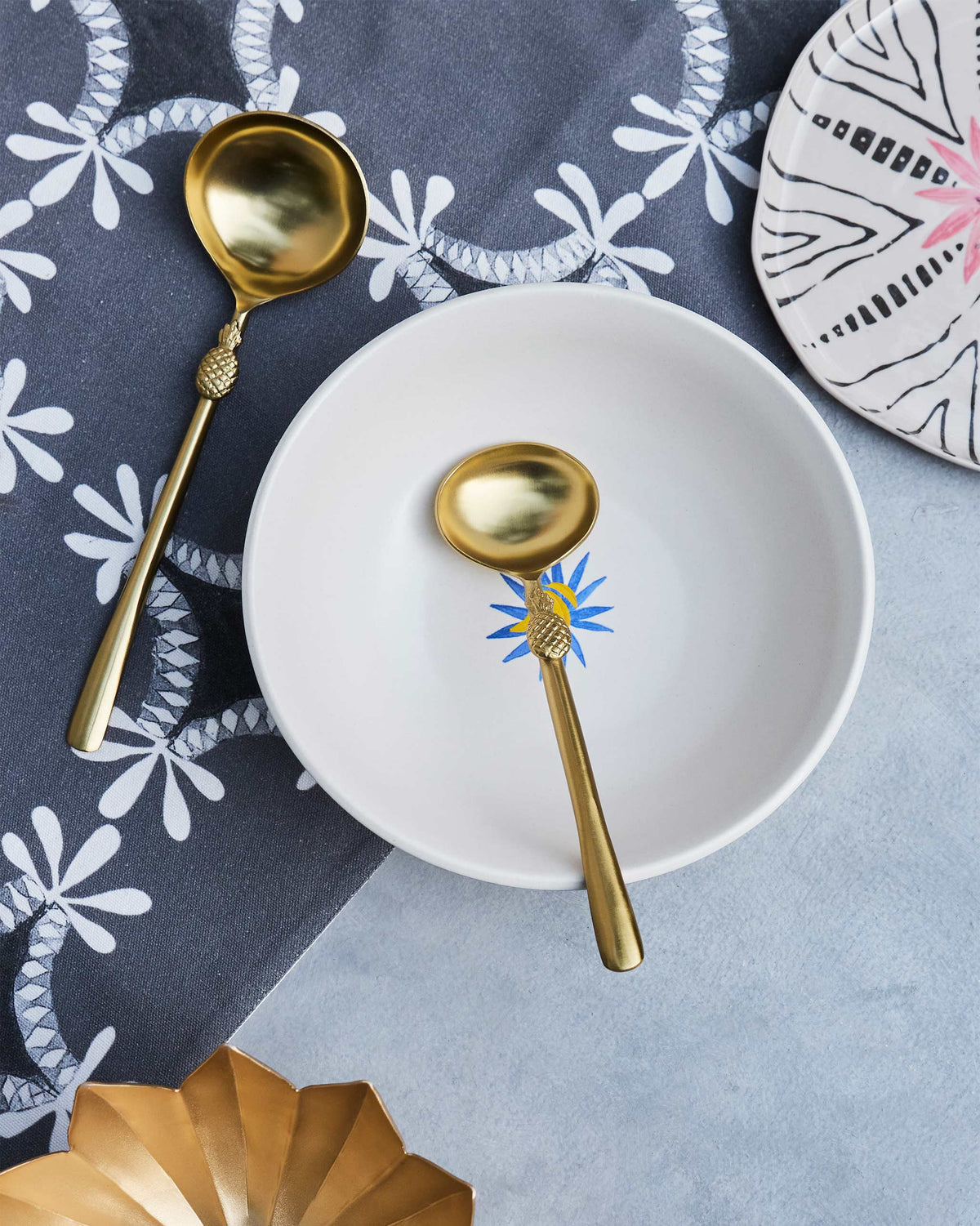 Pineapple Serving Spoon in gold, resting in a white bowl.