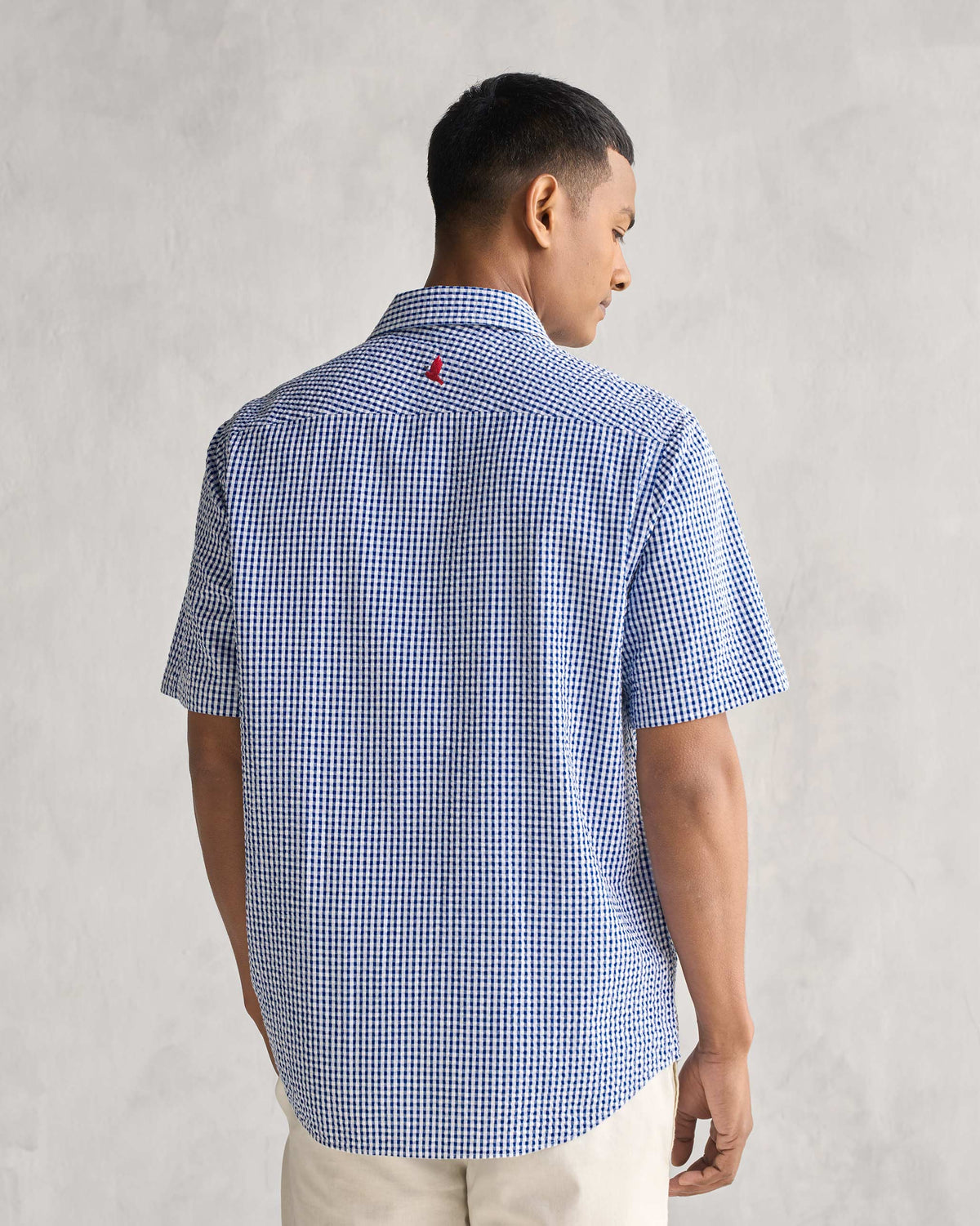Back of the Holiday Shirt in blue and white gingham check worn by a person.
