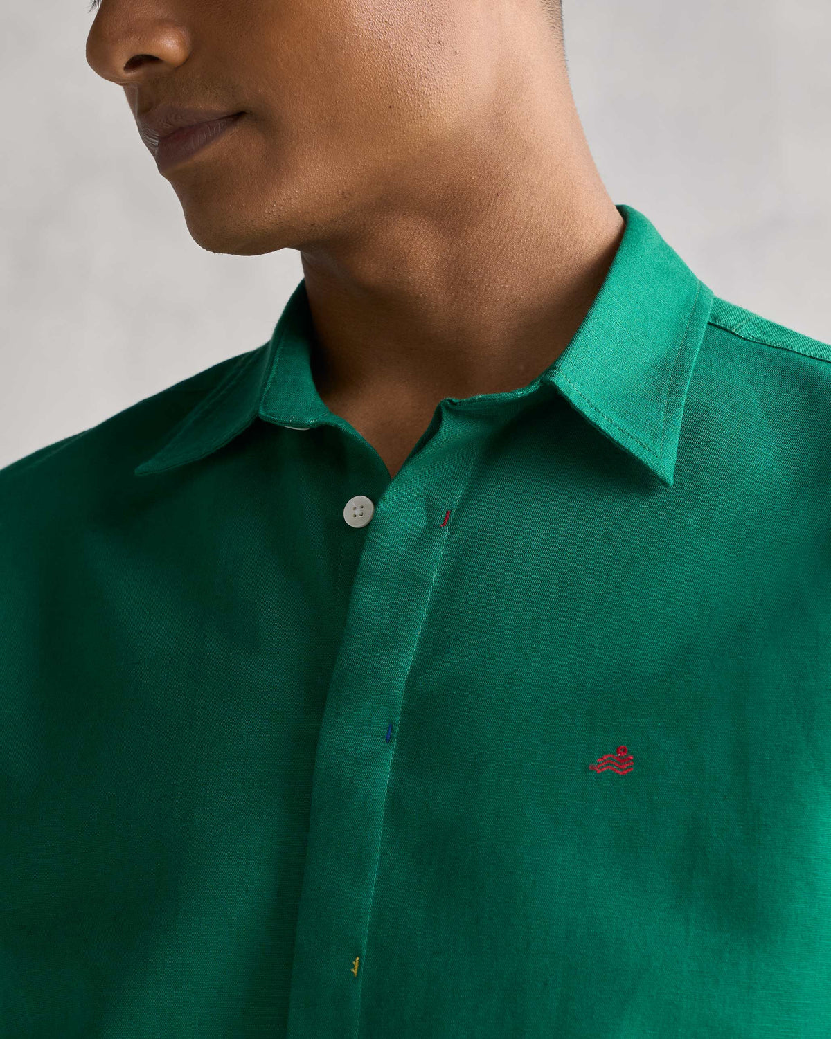 Close-up of the green Captain shirt showing its collar and a small red embroidered mark.