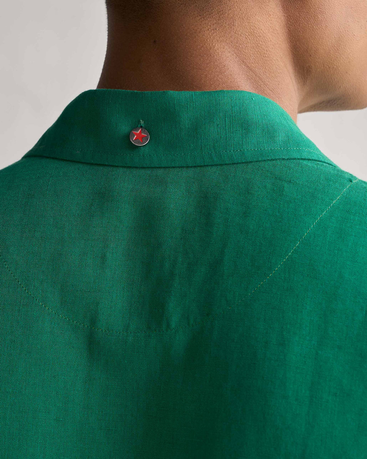 Close-up of the green Captain shirt collar with a red star button at the back.
