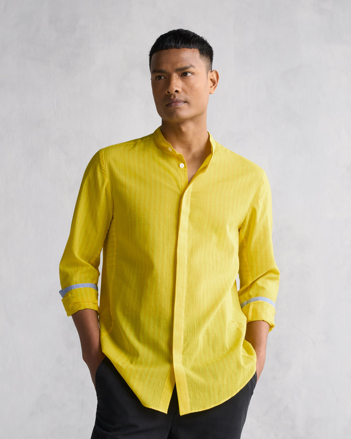 Person wearing a yellow Side Placket shirt with check cuff lining.