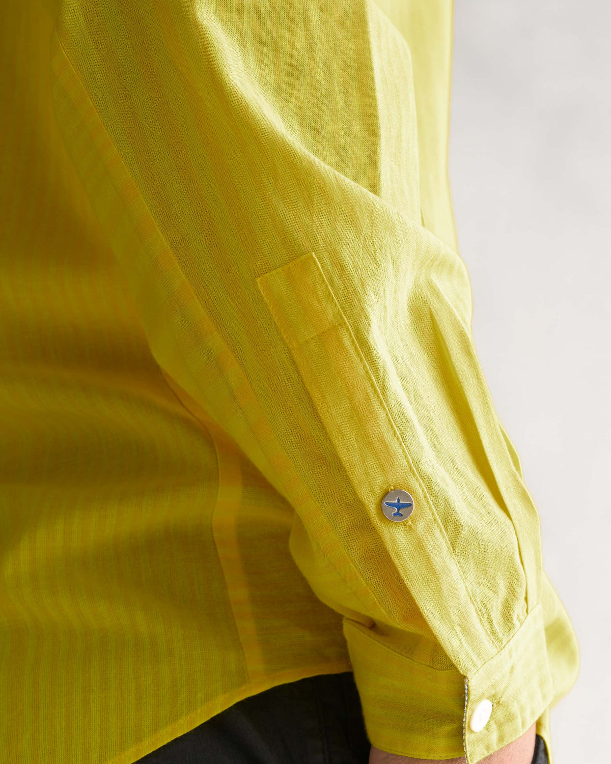 Close-up of a yellow Side Placket shirt sleeve with a round button cuff.