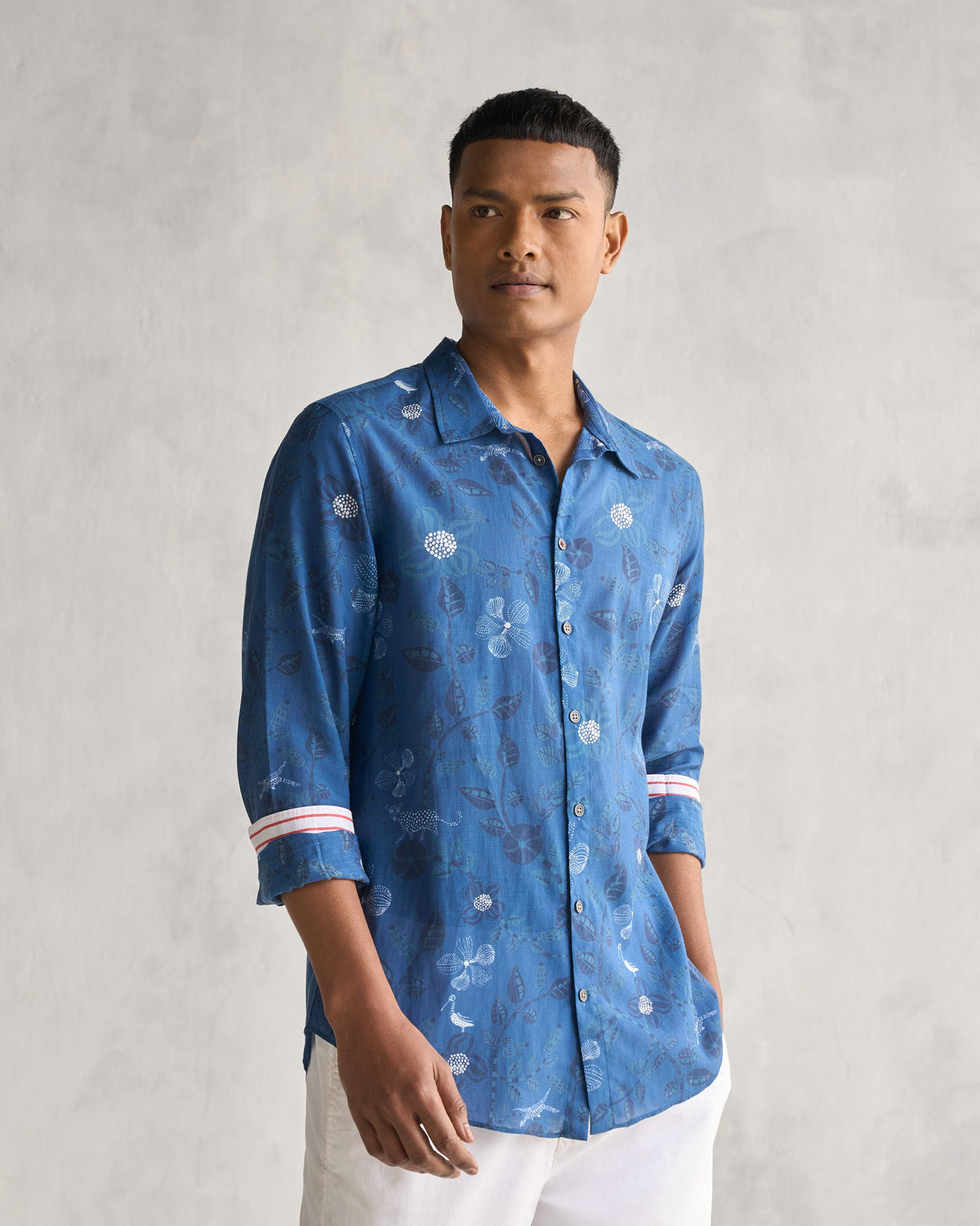 Person wearing a navy Hakuna Shirt with a leaf and flower print.