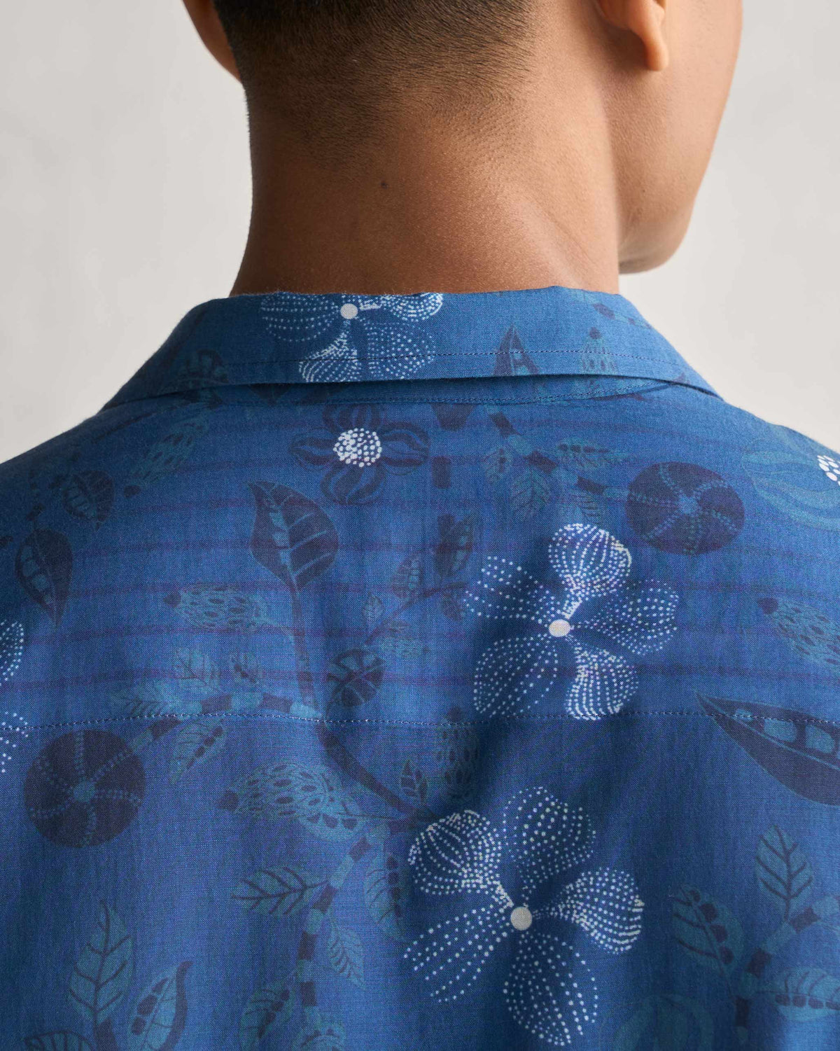 Close-up of the back collar of a navy Hakuna Shirt showing its print.