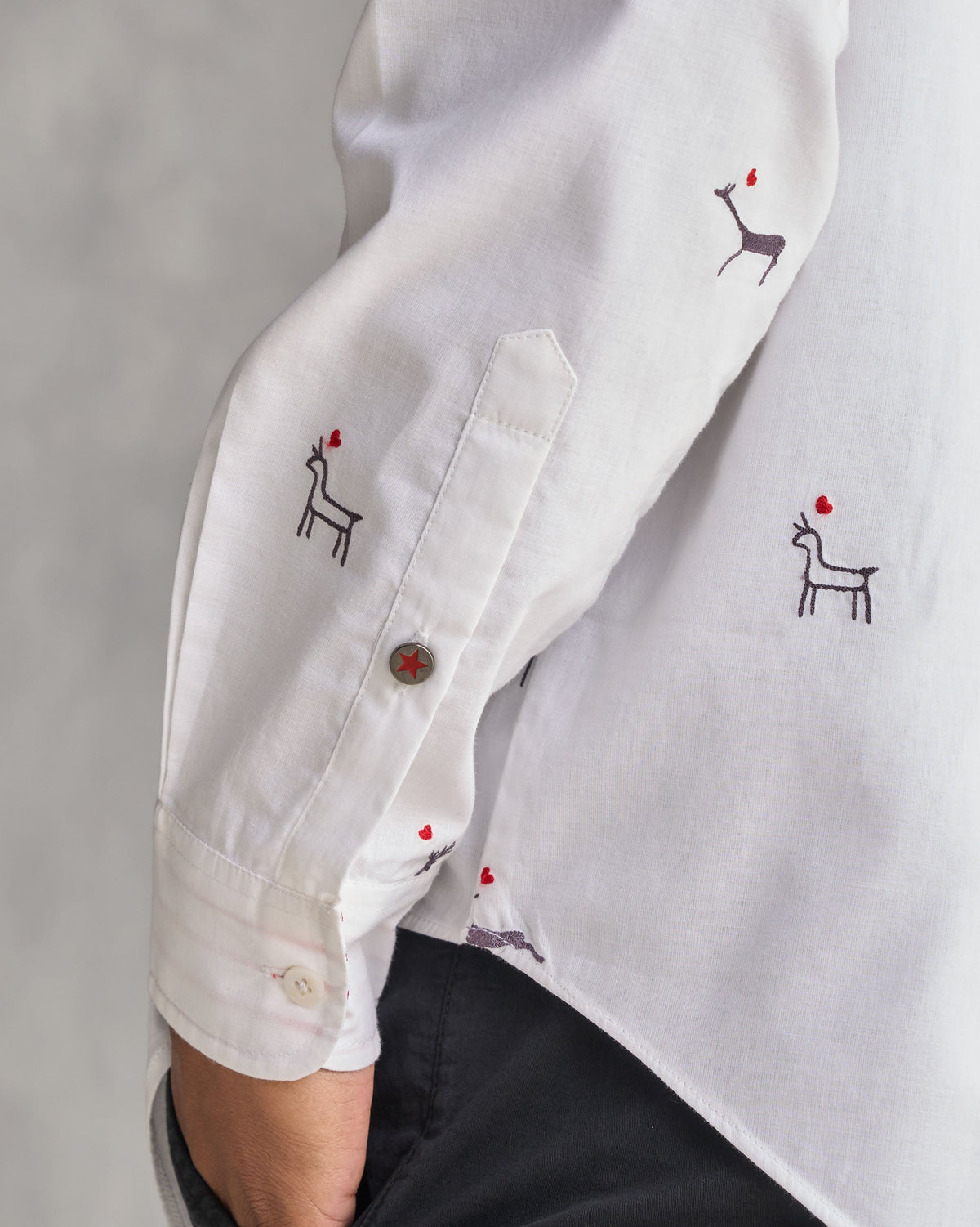 Close-up of the Classic Band Collar Shirt showing embroidered deer and a red-starred cuff button.