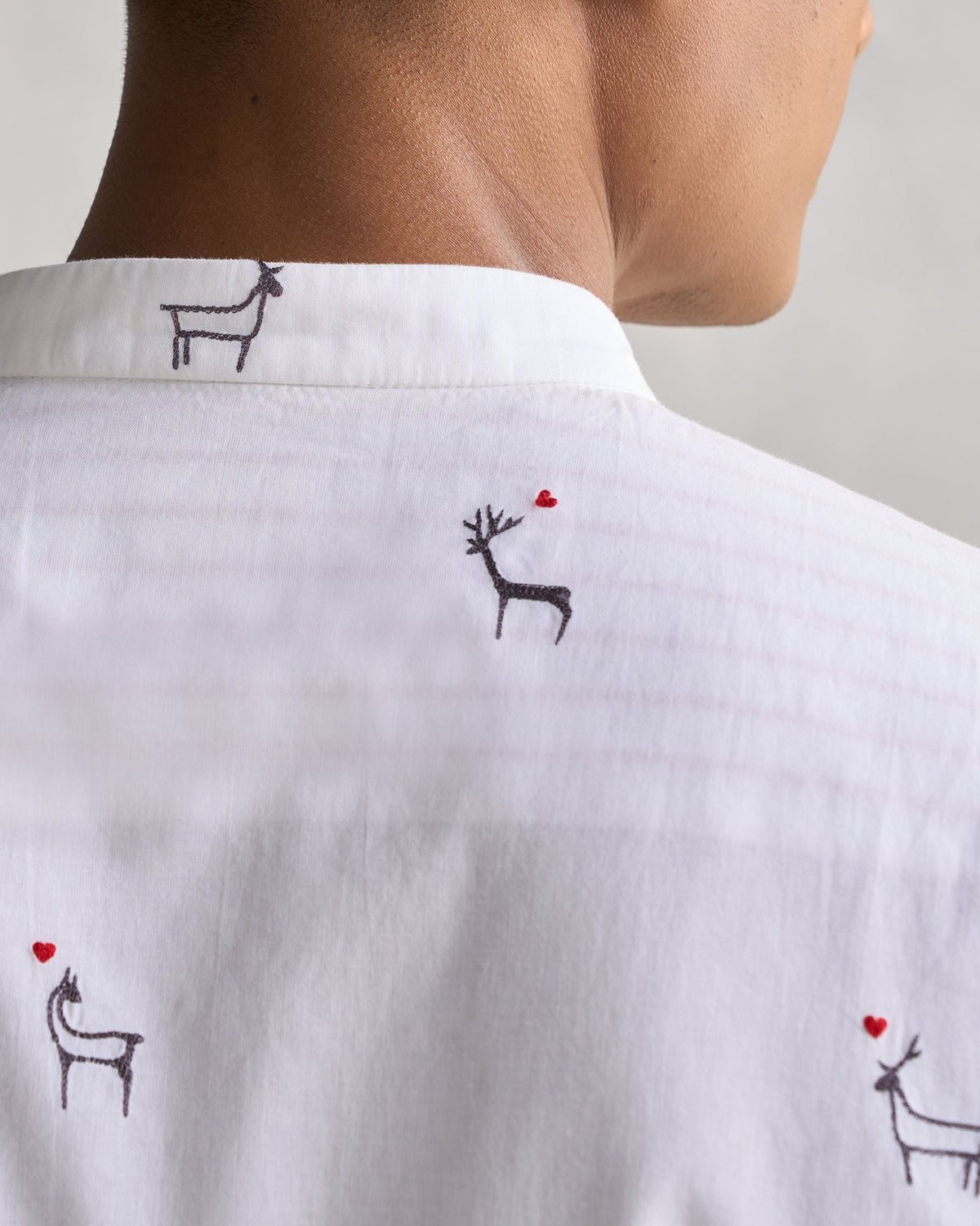 Close-up of the Classic Band Collar Shirt's collar, showing embroidered deer with red hearts.