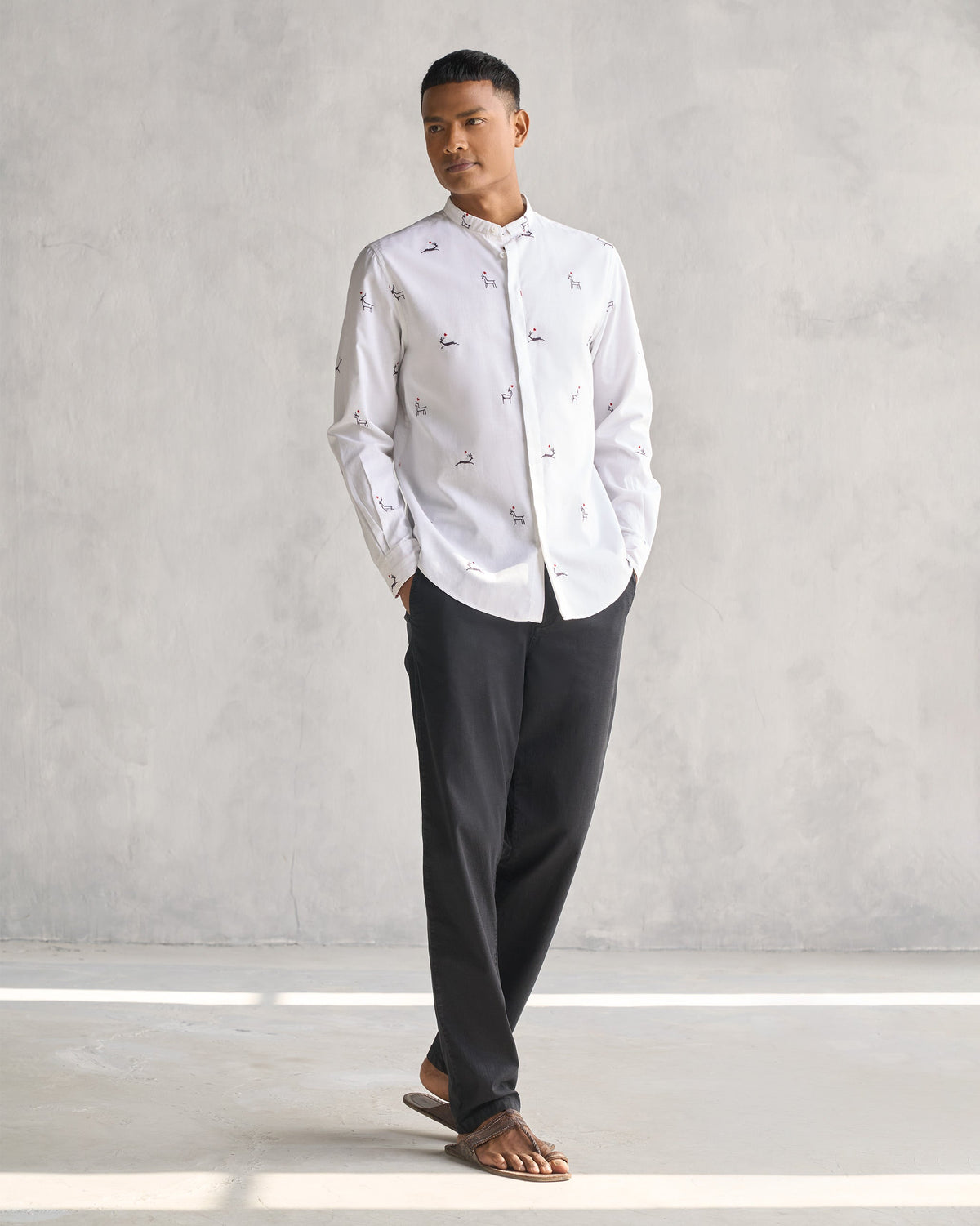 Full-length shot of a white Classic Band Collar Shirt with embroidered deer worn by a person.