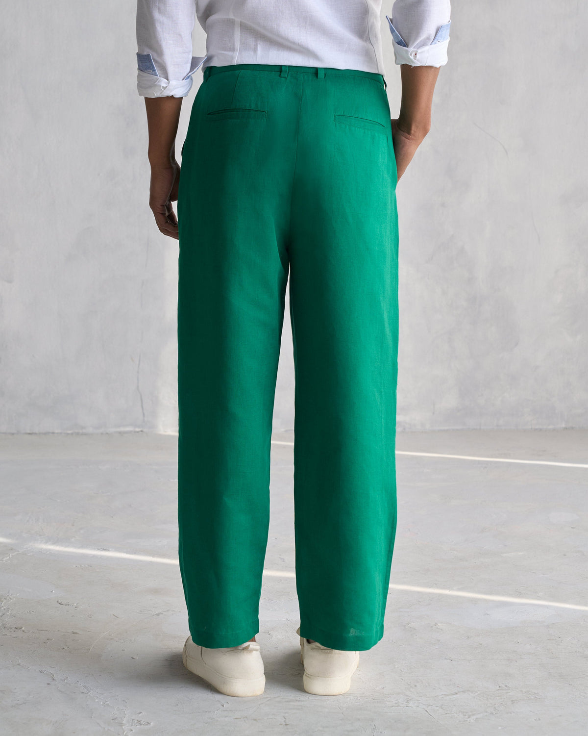 Back of green Pleated Pants showing welt back pockets.