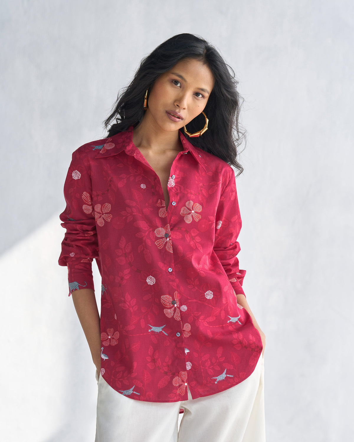 Person wearing a red Tropico Shirt with a floral print.
