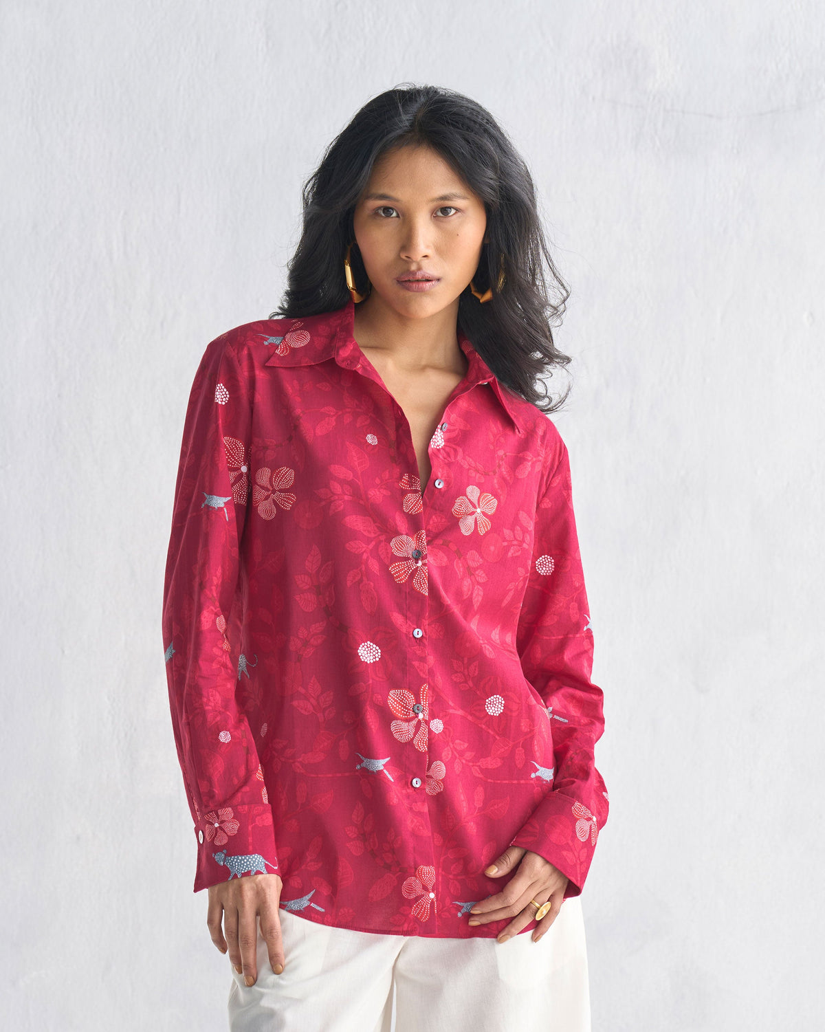 Person wearing a red Tropico Shirt with long sleeves and a floral print.