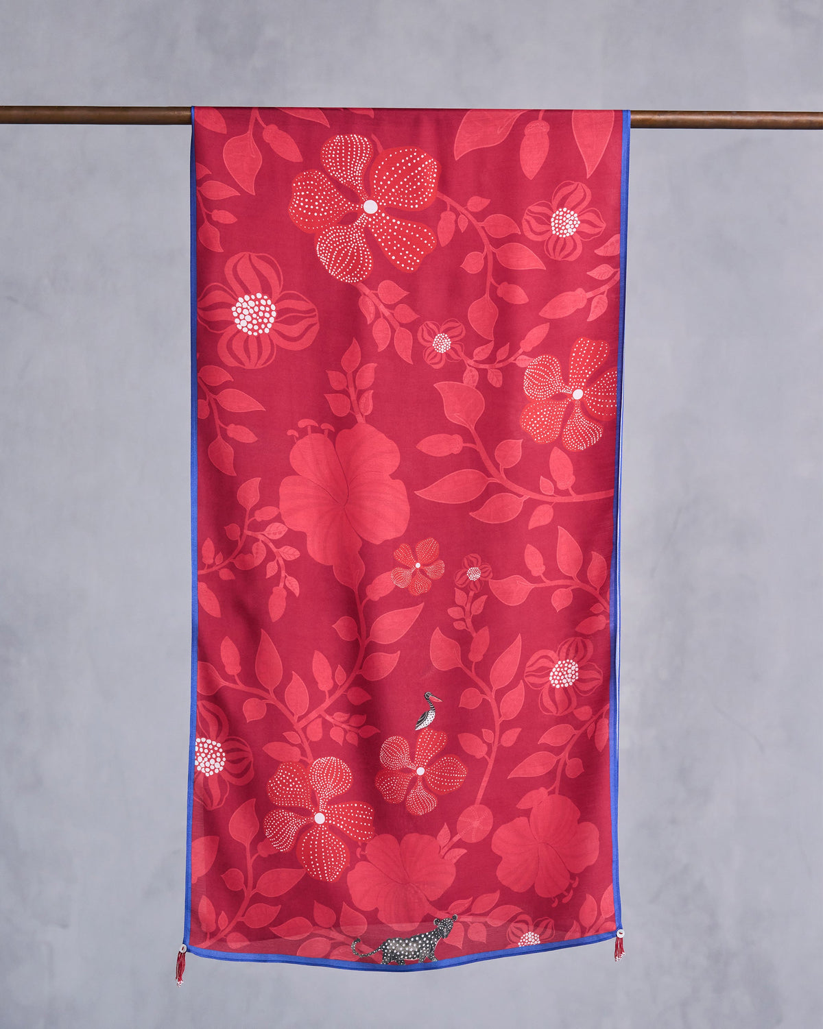 Red Roseate scarf hung flat, showing tonal flowers and leaves with blue trim.