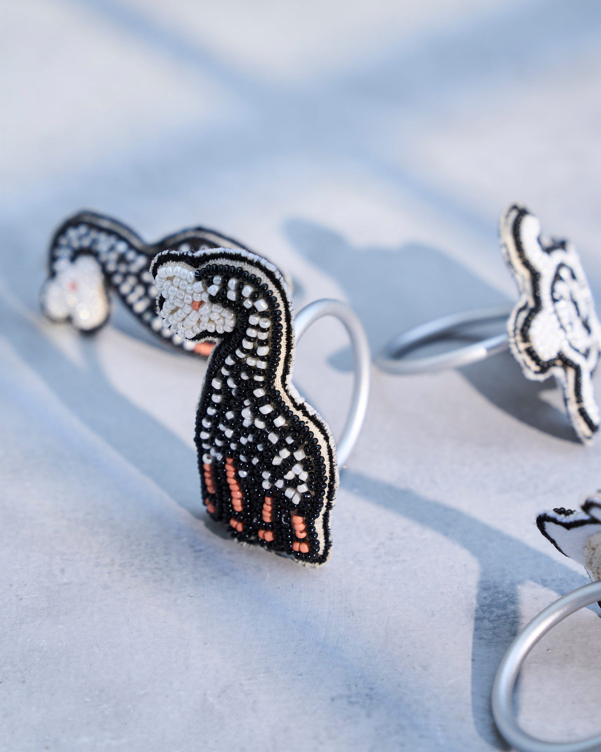 Close-up of a beaded Tinga Napkin Ring with a long-necked animal motif.