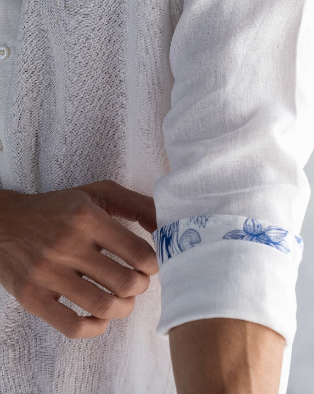 Close-up of a white Nawab shirt cuff showing blue floral trim inside.