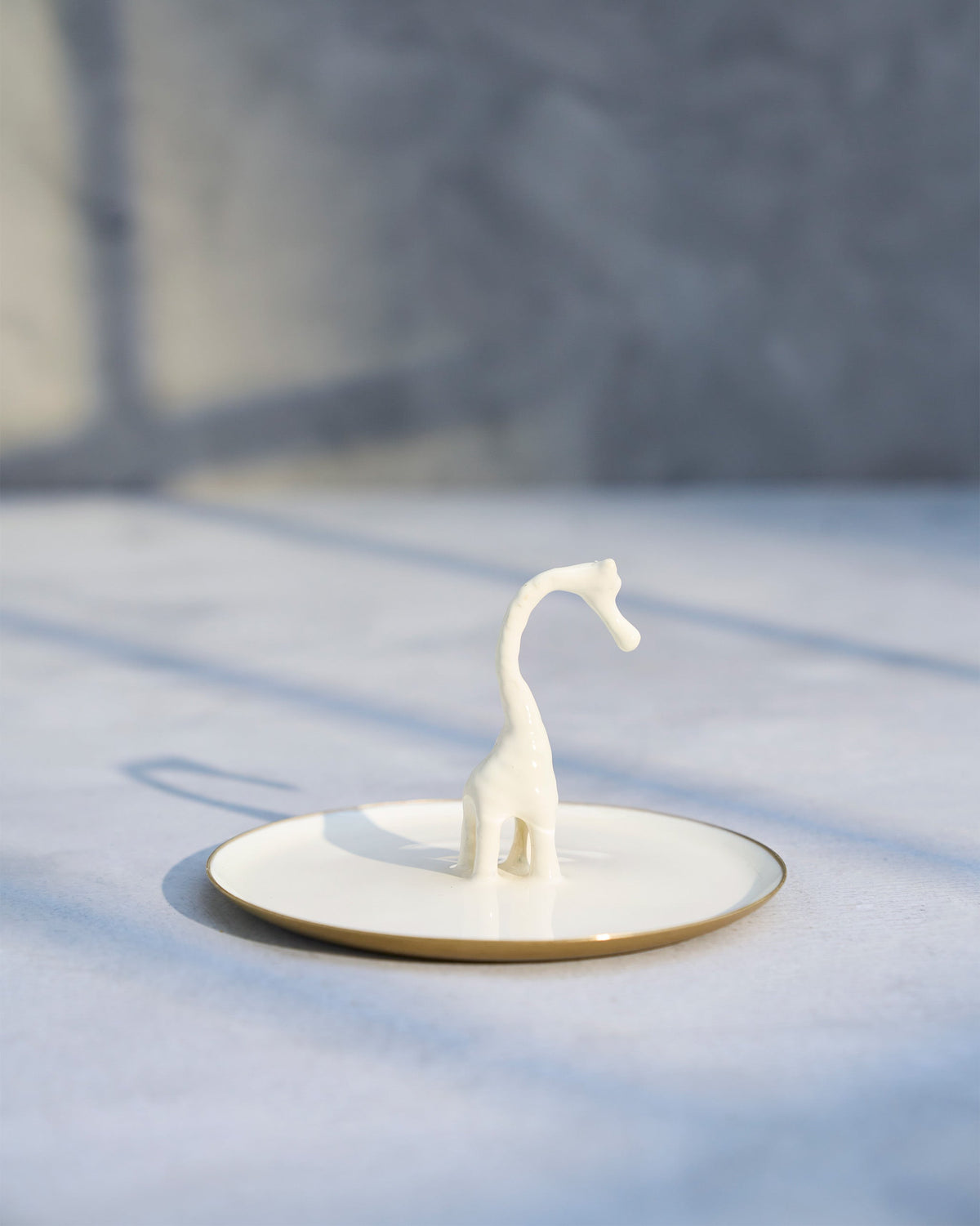 Side view of Giraffe Trinket Tray with a white giraffe figure standing on it.