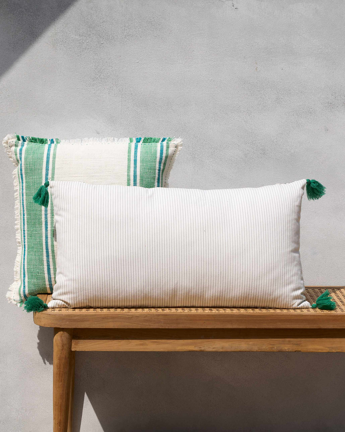 Clove Lumbar Cushion Cover in white pinstripe with green tassels.