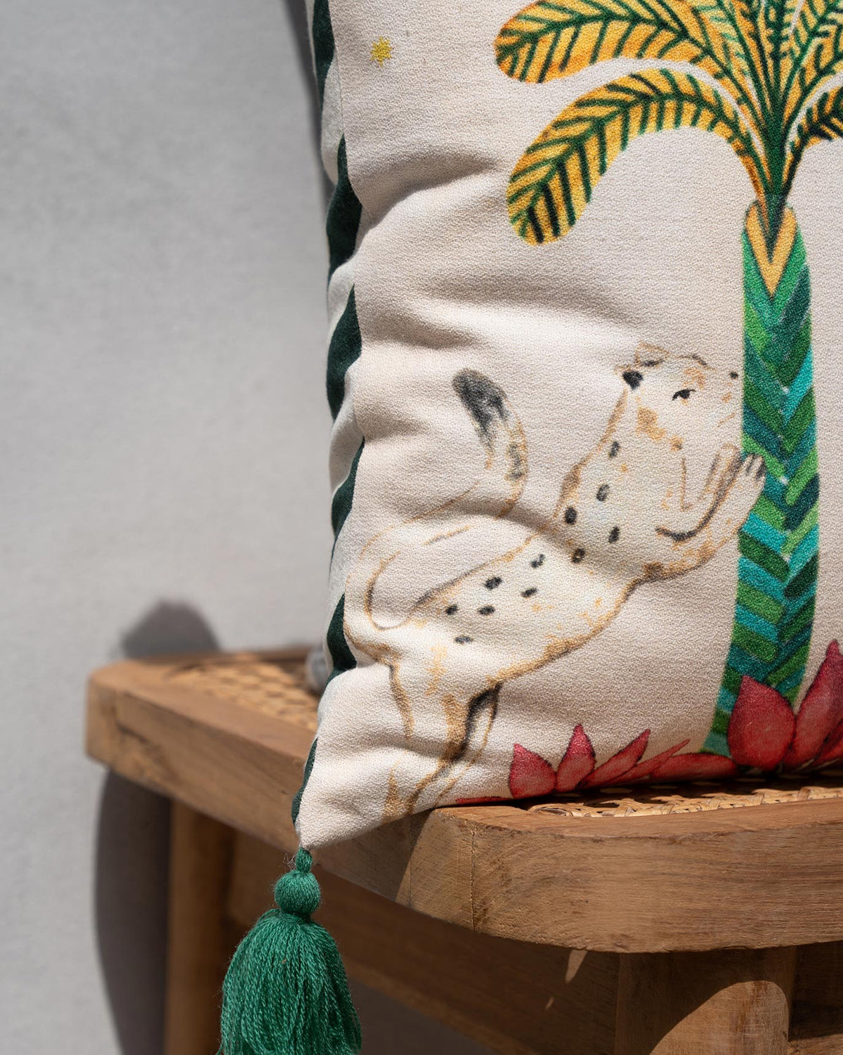Close-up of the Wild Trial Cushion Cover showing a spotted animal beside a palm tree.
