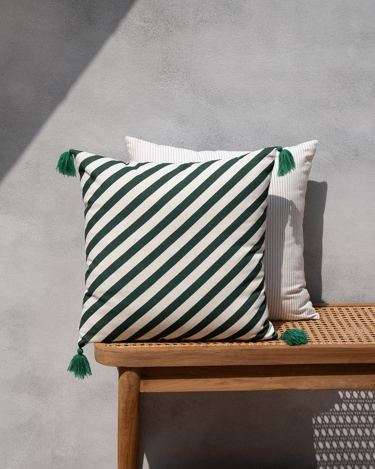 Wild Trial Cushion Cover in green and cream diagonal stripes with green tassels.