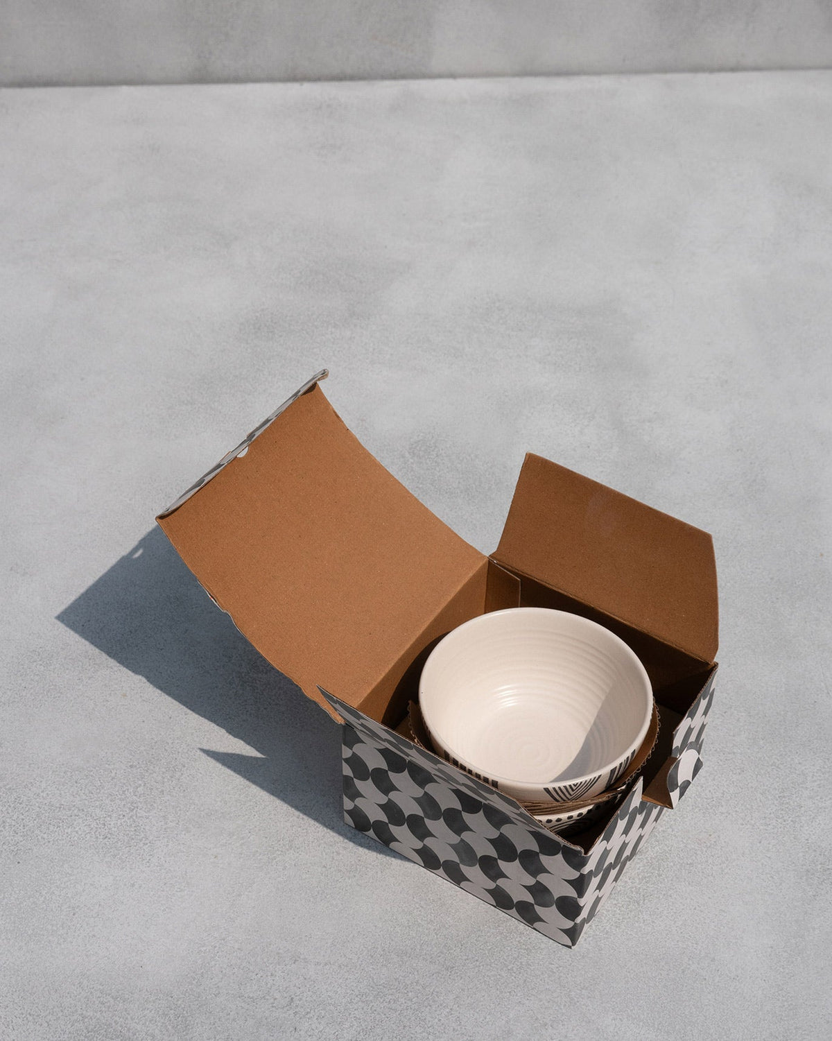 Serenity cereal bowls inside an open black and white patterned box.