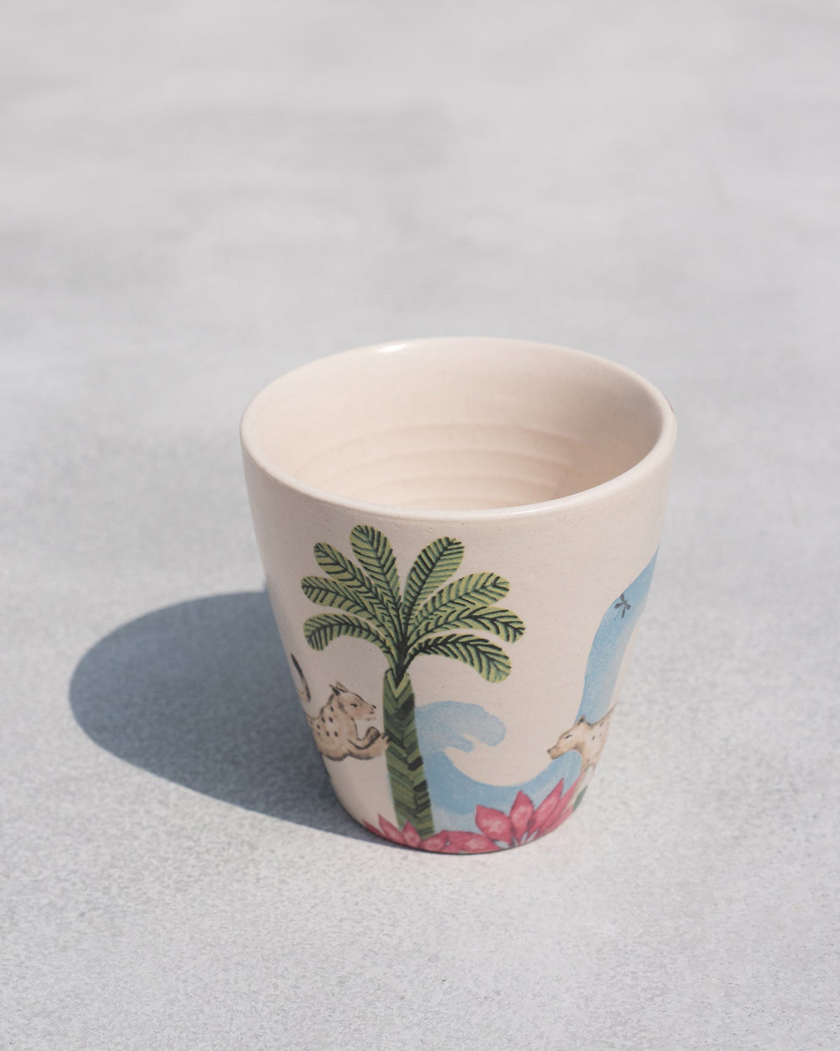 Overhead view of a Zanzibar Conical Mug showing a painted palm tree.