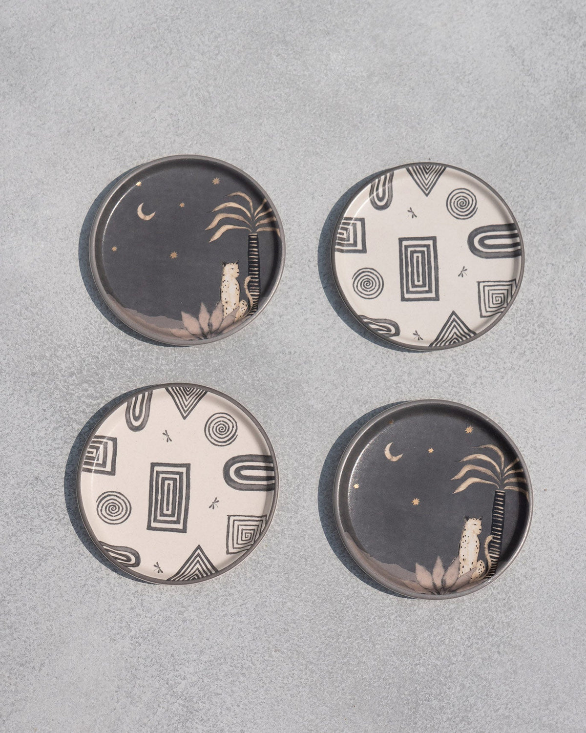 Set of four Serenity Coasters from above, two dark and two cream with geometric designs.