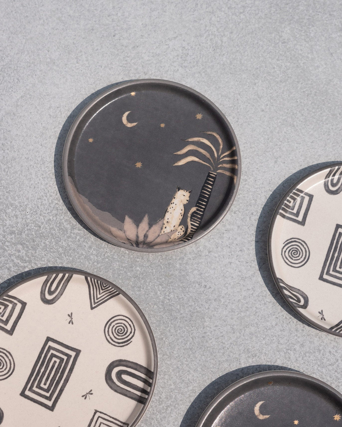 Close-up of a dark Serenity Coaster with a moon and palm motif.