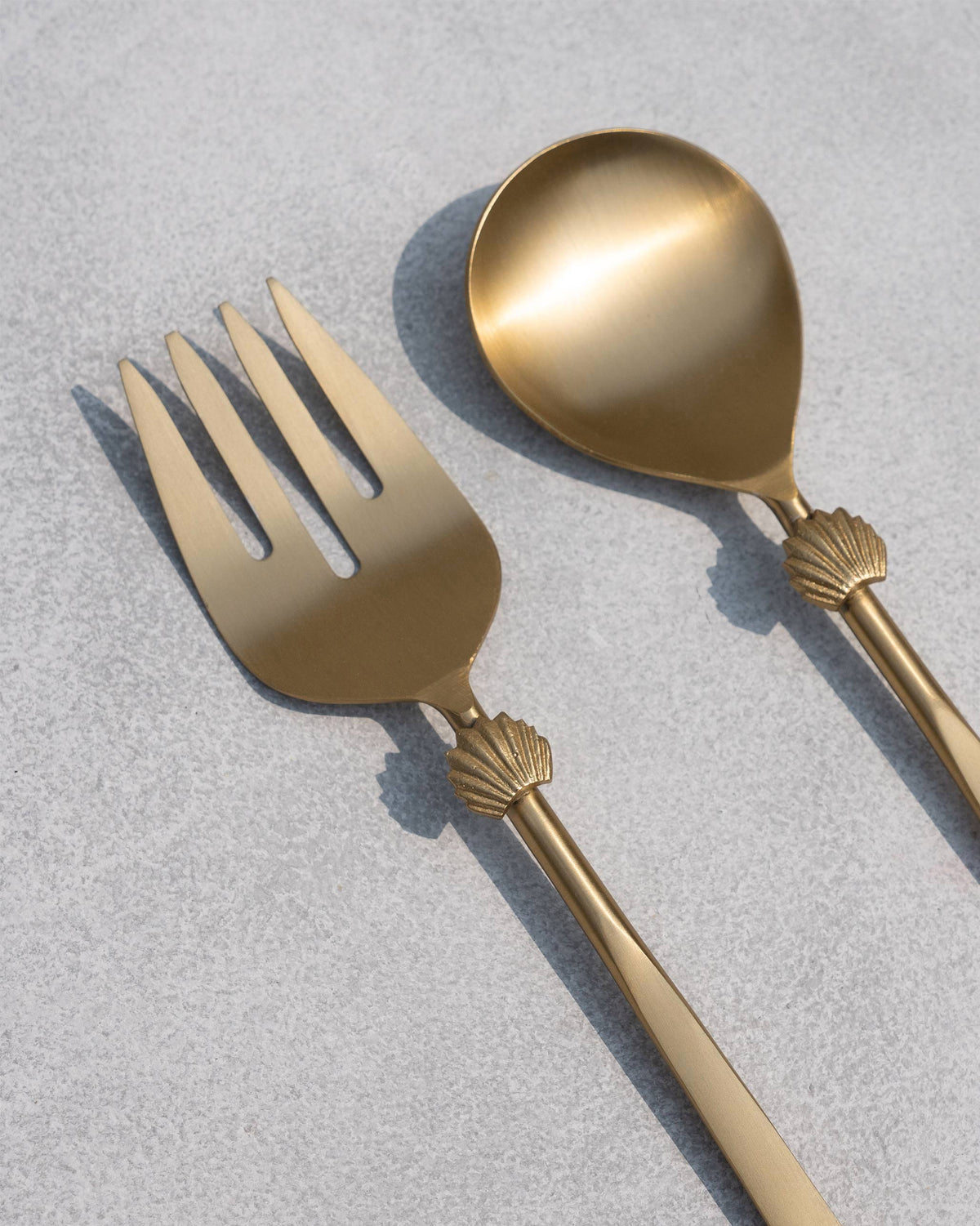 Close-up of the Seashell Salad Server fork and spoon showing shell handle detail.