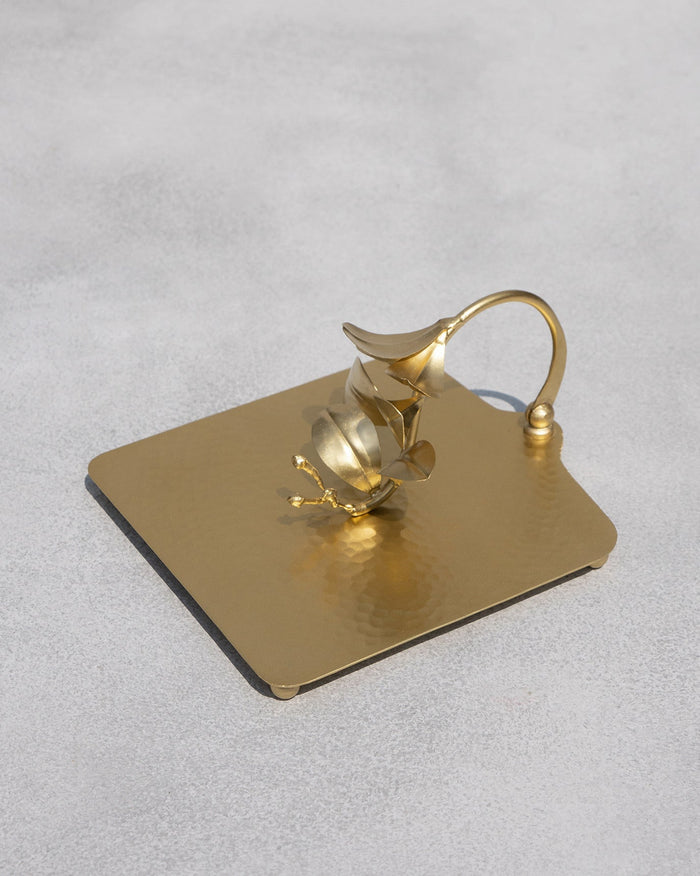 Clove Branch gold napkin holder with leaf weight on a hammered square base.
