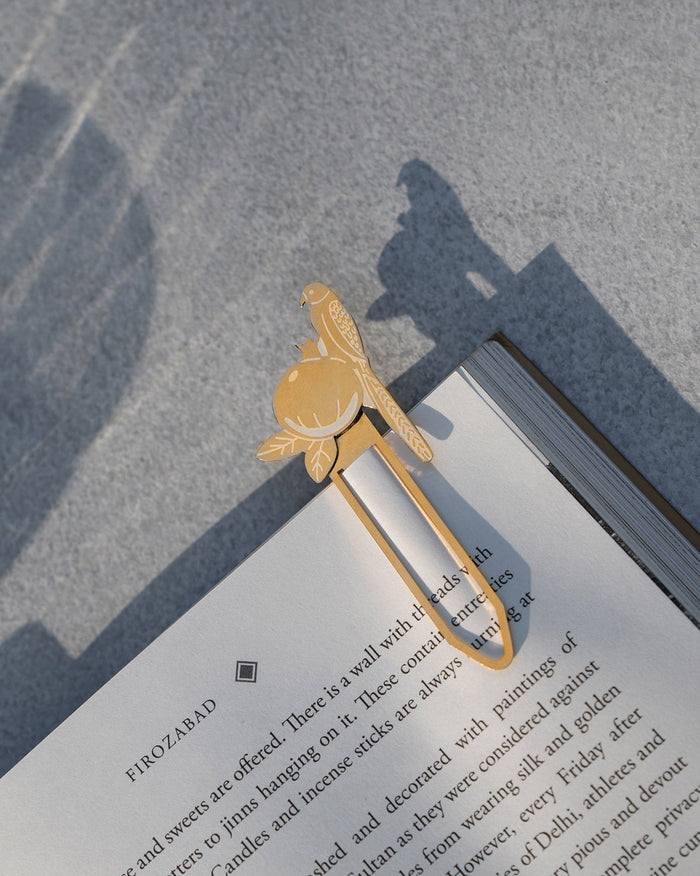 Safari Tota Bookmark in gold with a parrot and pomegranate motif.