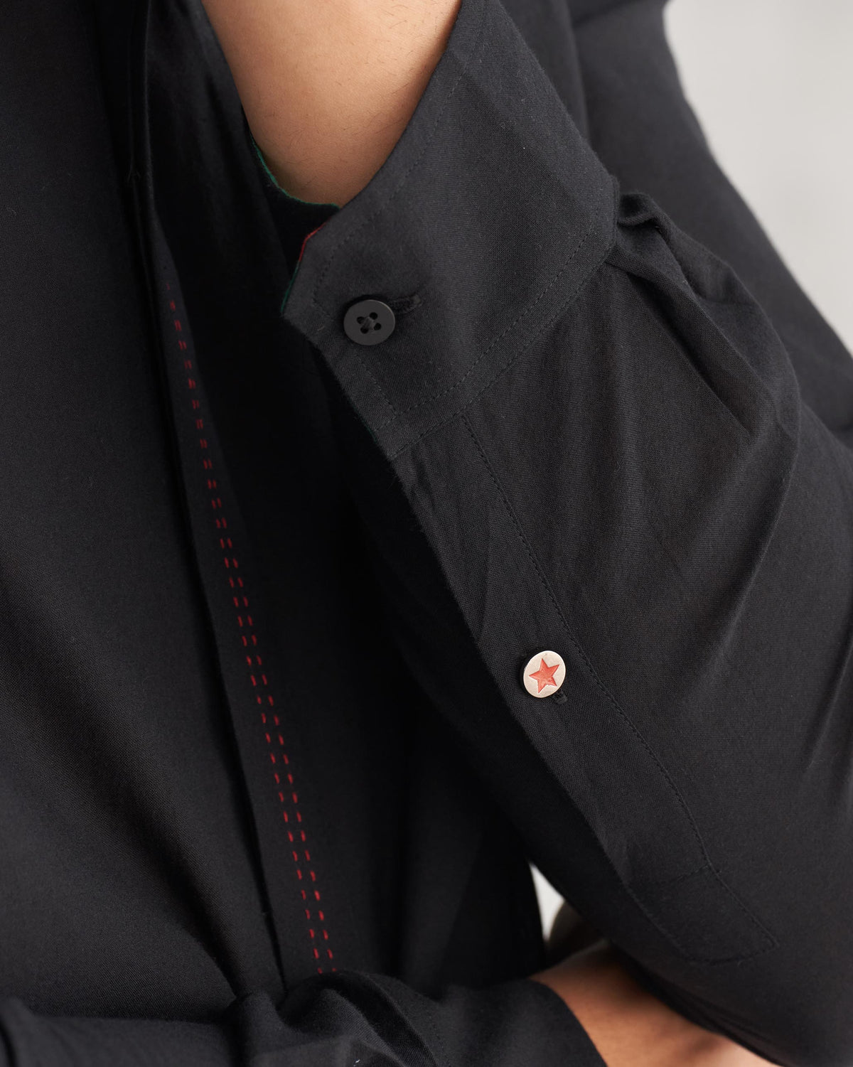 Close-up of a Valley shirt's sleeve cuff with a red star button.