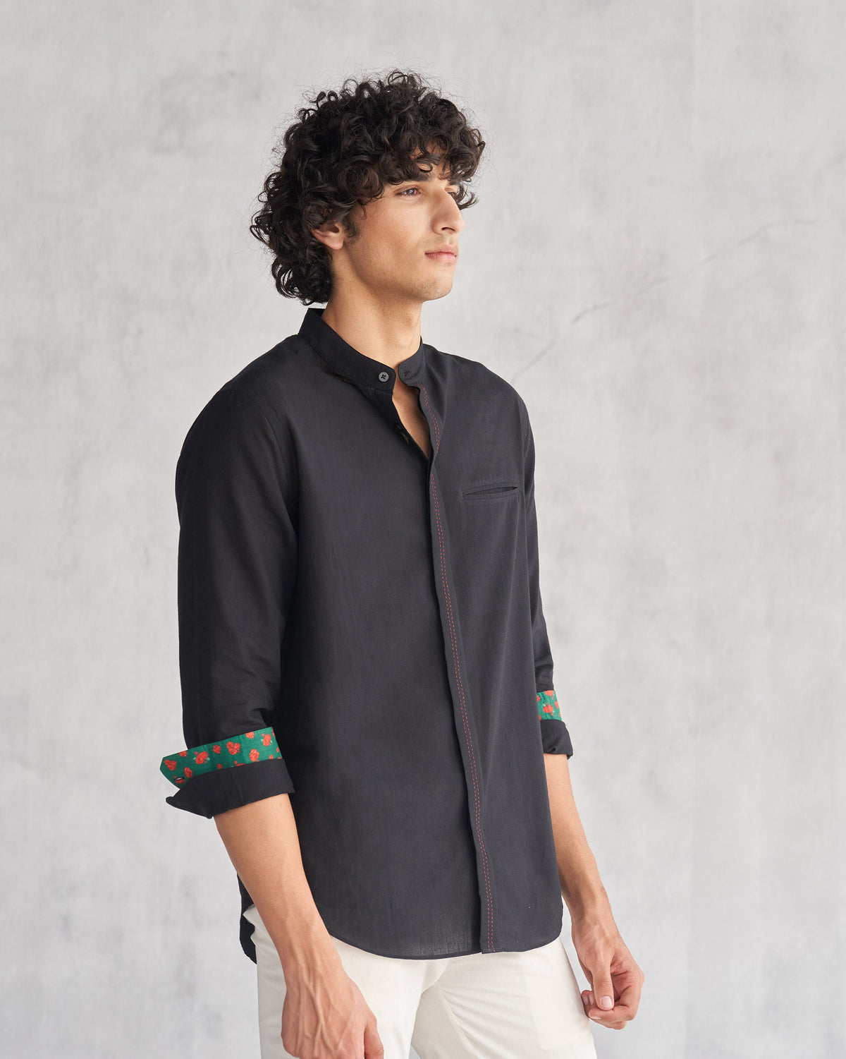 Three-quarter view of a black Valley shirt with a chest pocket worn by a person.