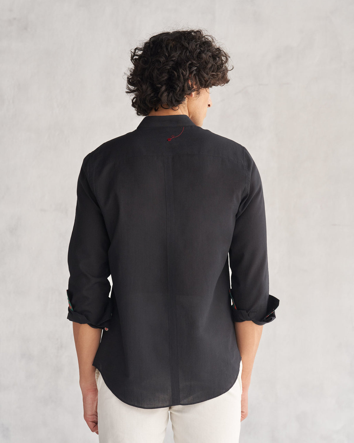 Back of a black Valley shirt with printed cuff linings worn by a person.
