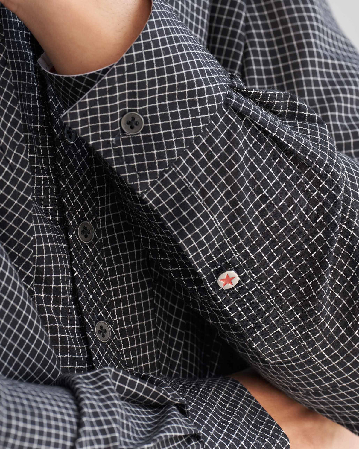 Close-up of the Big Pocket shirt sleeve, with a red star button.