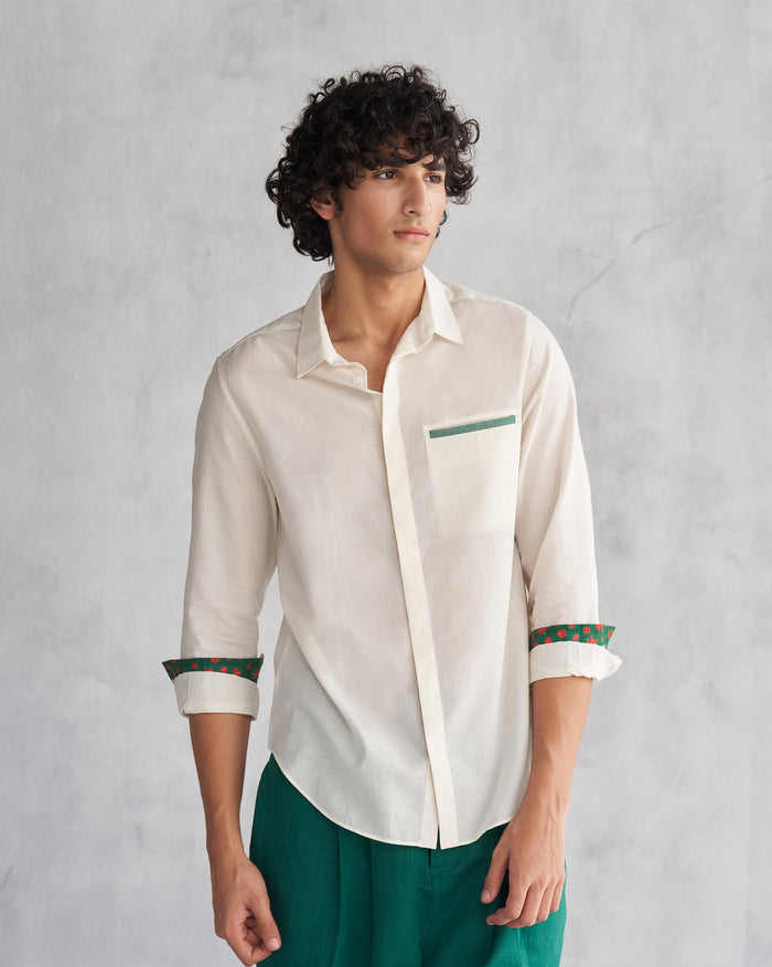 Person wearing an ivory Kangra Shirt with a green-trimmed chest pocket.