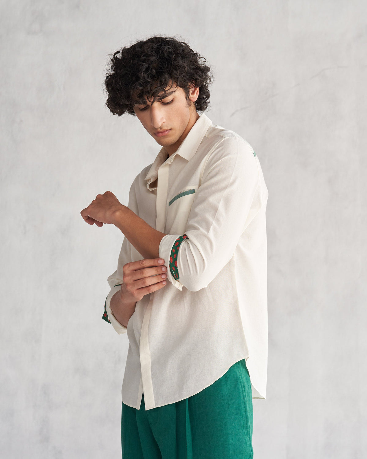 Person wearing an ivory Kangra Shirt with rolled sleeves showing patterned cuff lining.