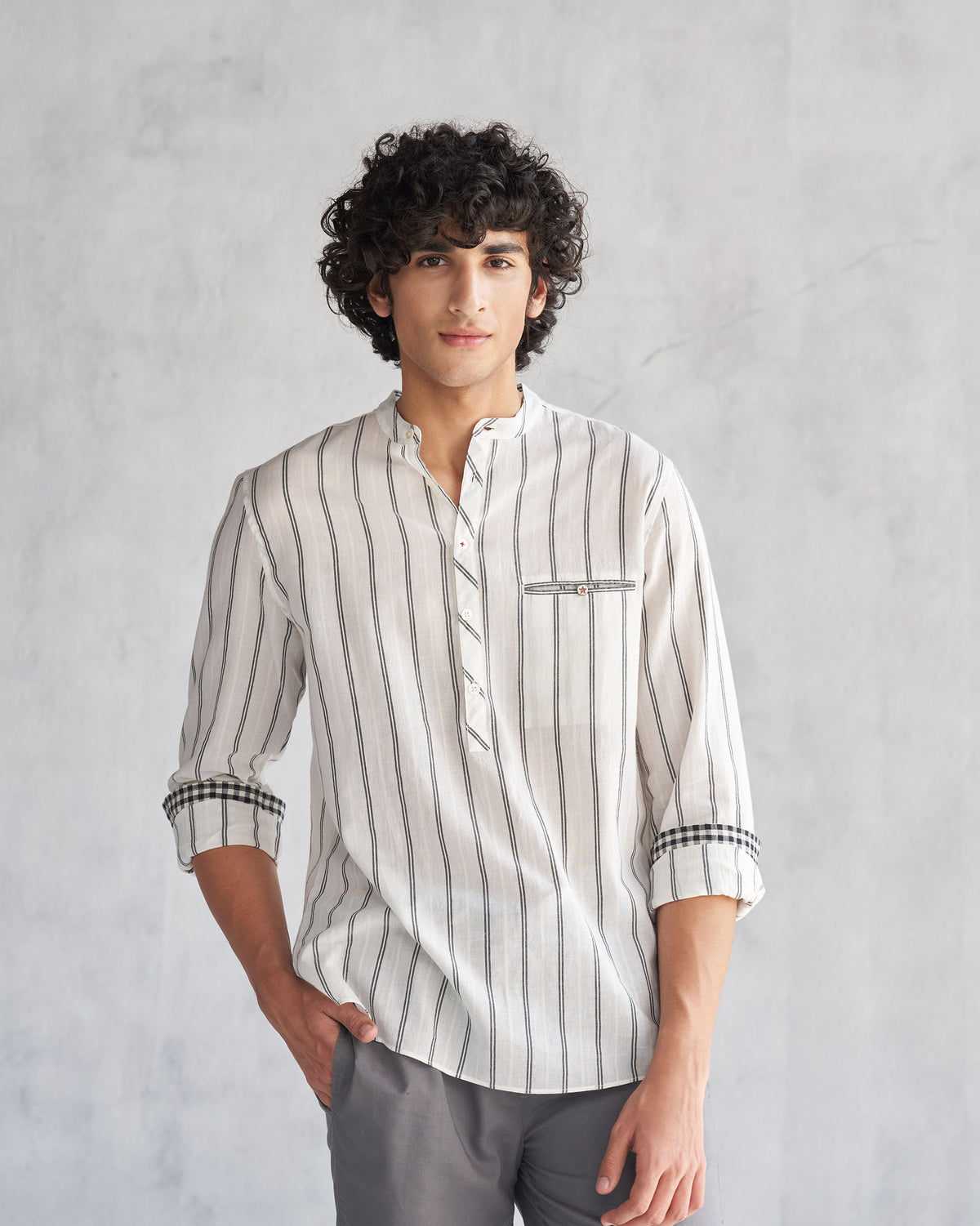 Person wearing an ivory and black Pondicherry shirt with checked cuff linings.