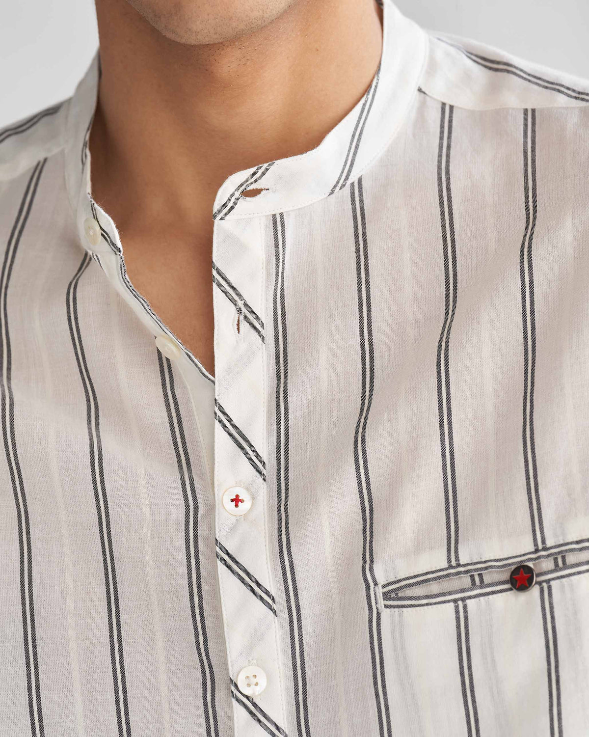 Close-up of an ivory and black Pondicherry shirt showing its band collar, placket and pocket.