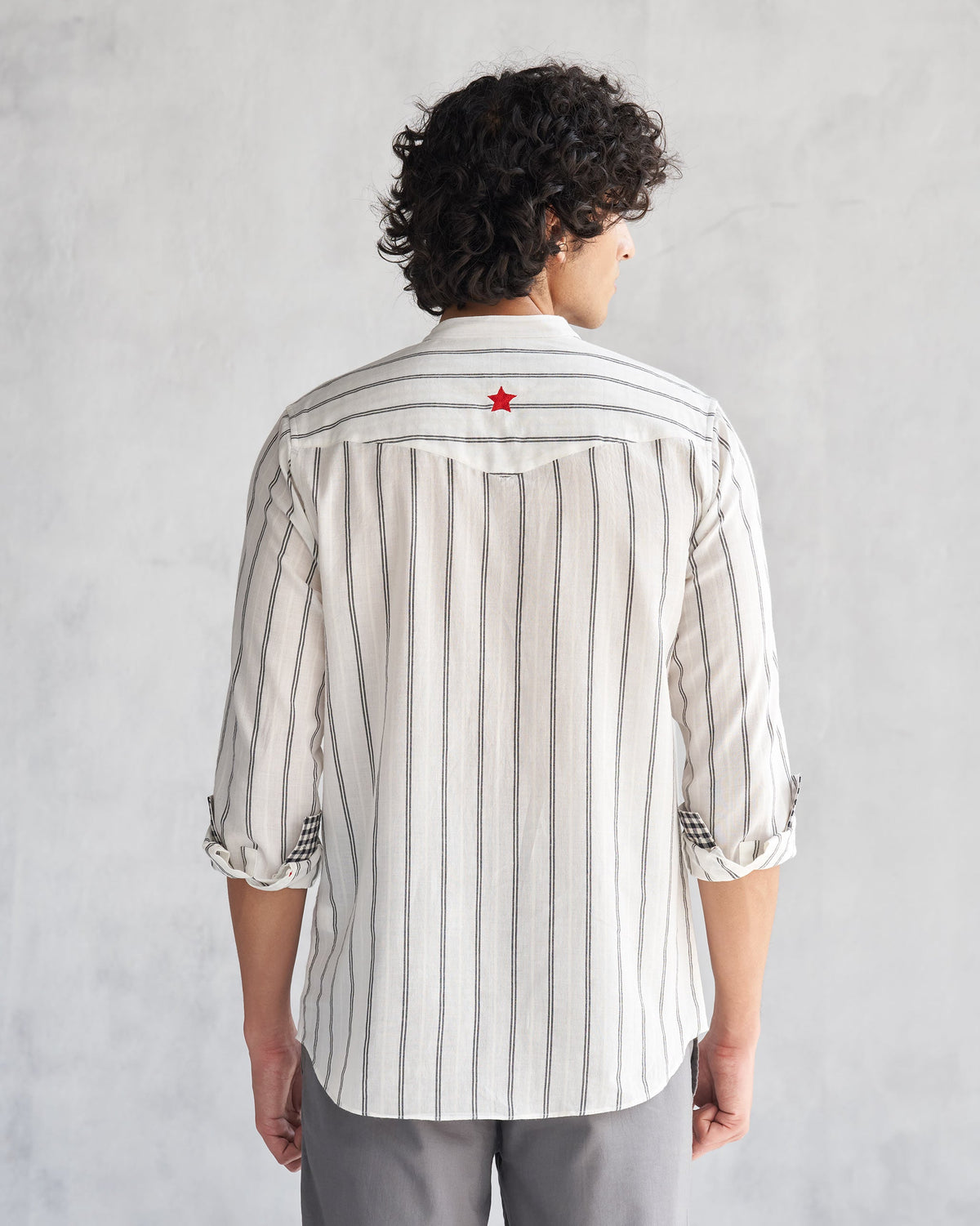 Back of an ivory and black Pondicherry shirt worn by a person, with a red star on the upper back.